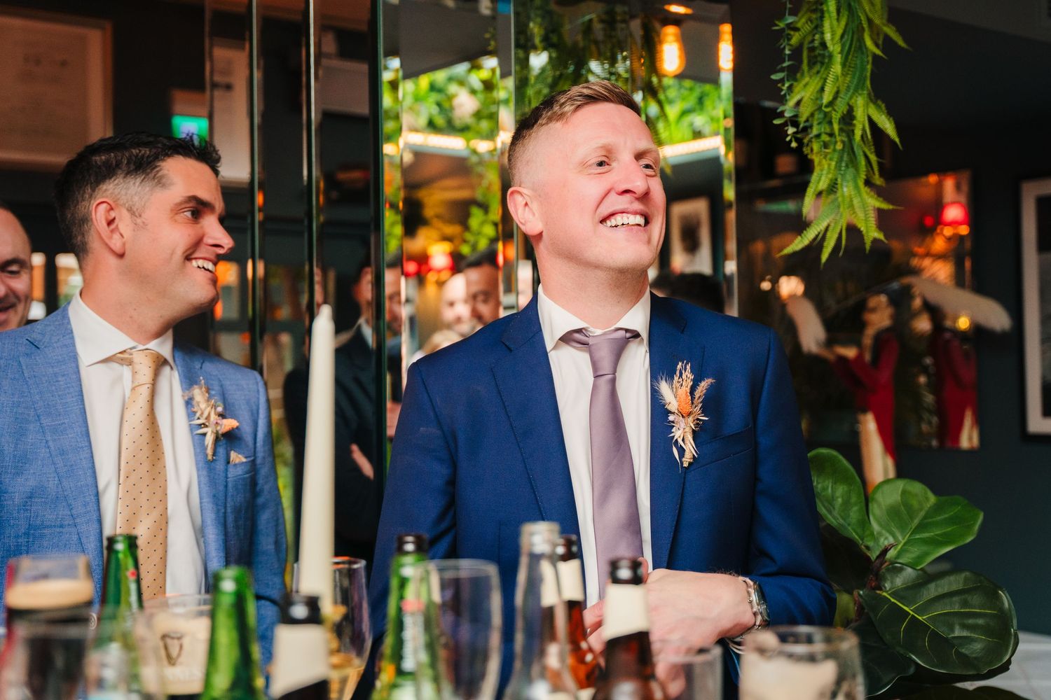Wedding guests laughing and enjoying themselves at a decorated reception venue.
