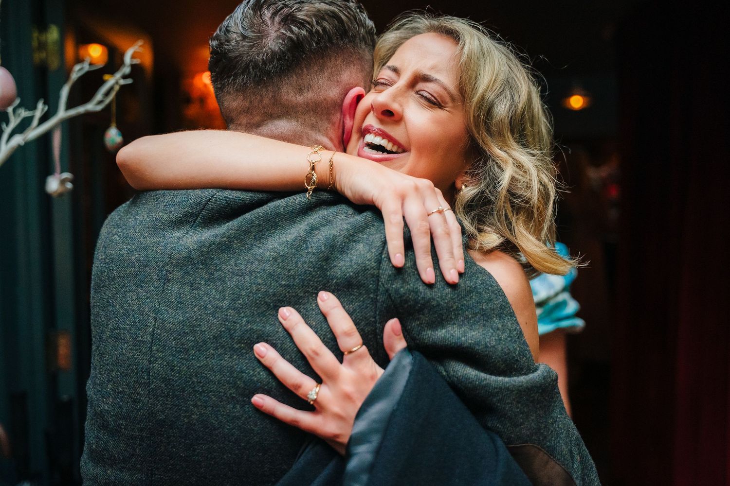 Emotional embrace between two people at an evening celebration.