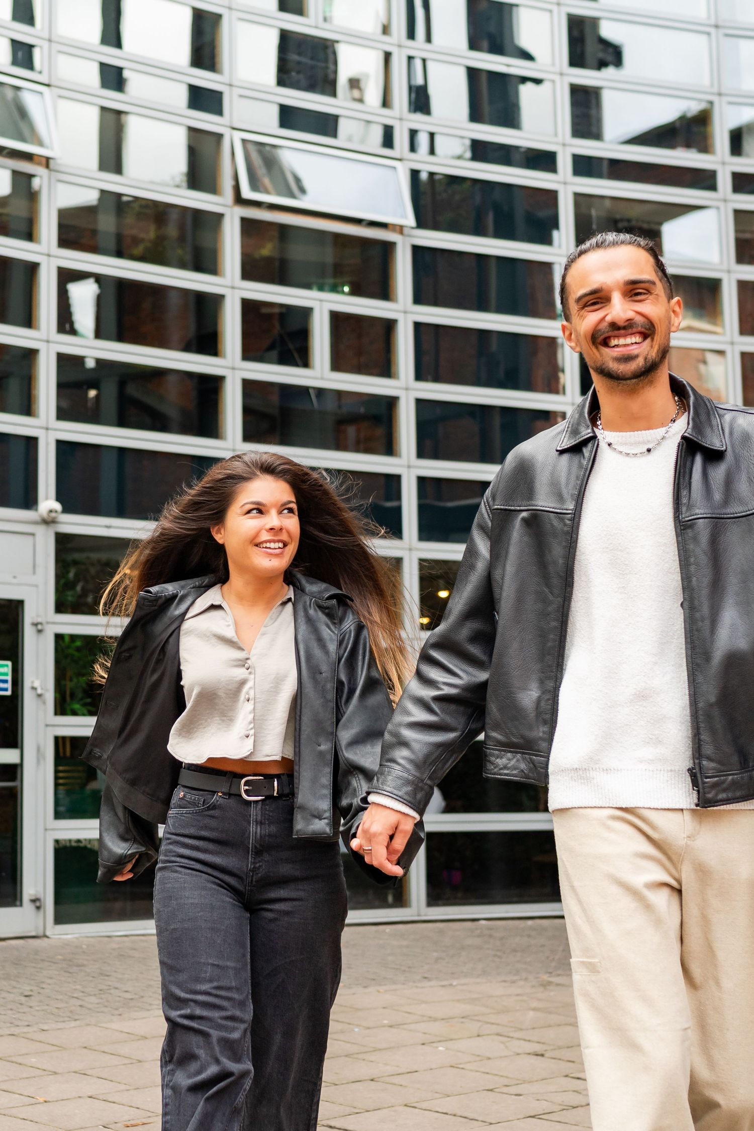 Modern couple sharing a joyful moment while walking together outside a commercial building. Couple's Photoshoot PHOTOGRAPHER Dublin