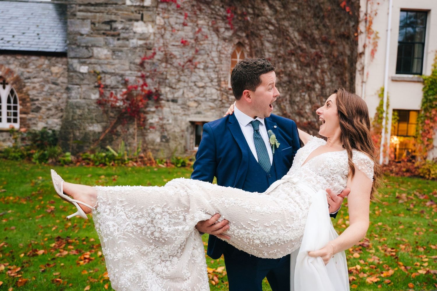 Couple dances and spins together against historic stone wall backdrop.
