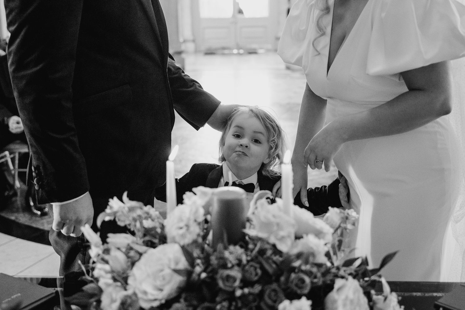 Wedding ceremony with floral arrangements and guests seated in a classic venue. Wedding photographer dublin