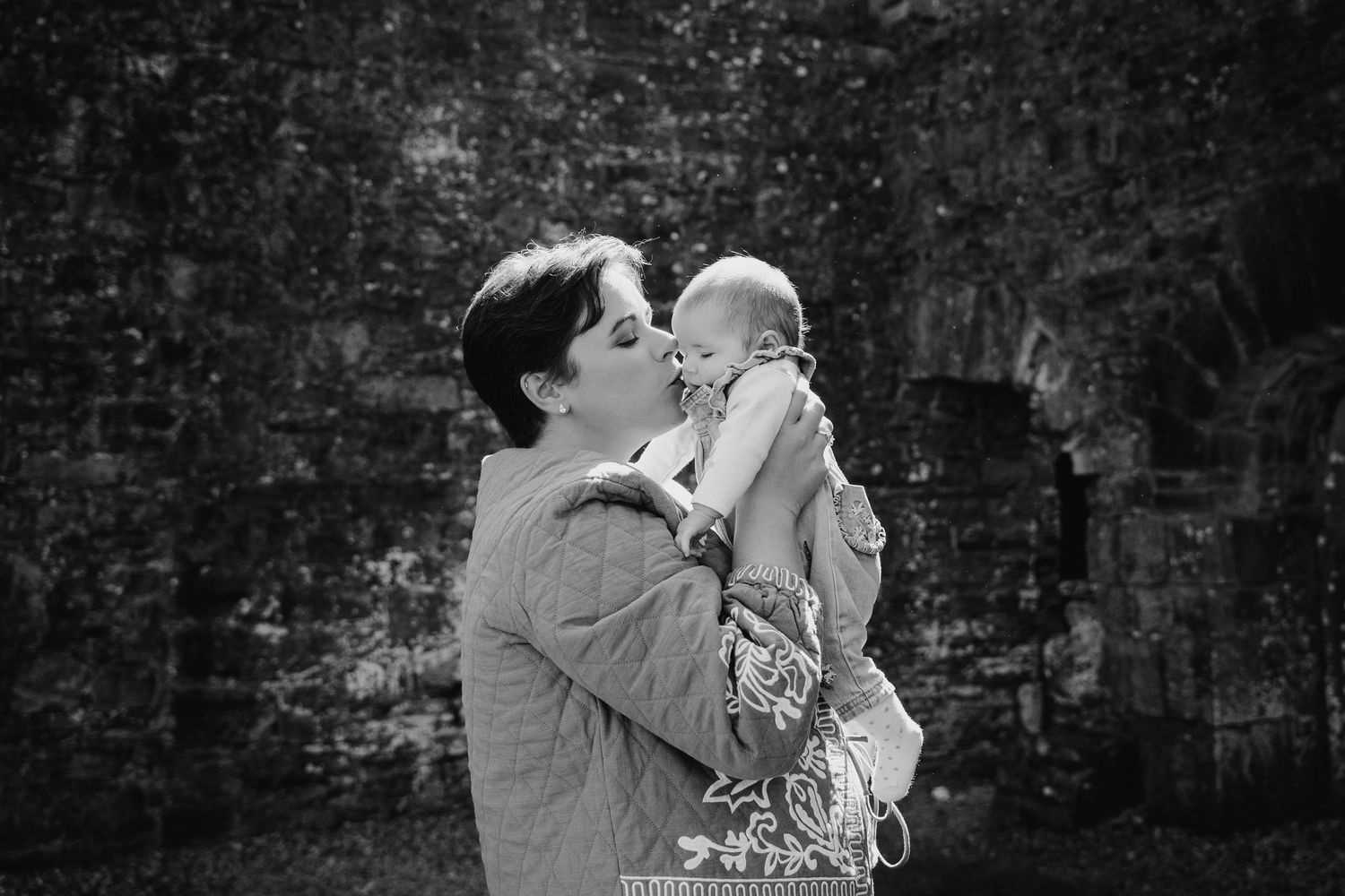 Couple holding their newborn baby in a tender moment captured in black and white photography. Family PHOTOGRAPHER Dublin