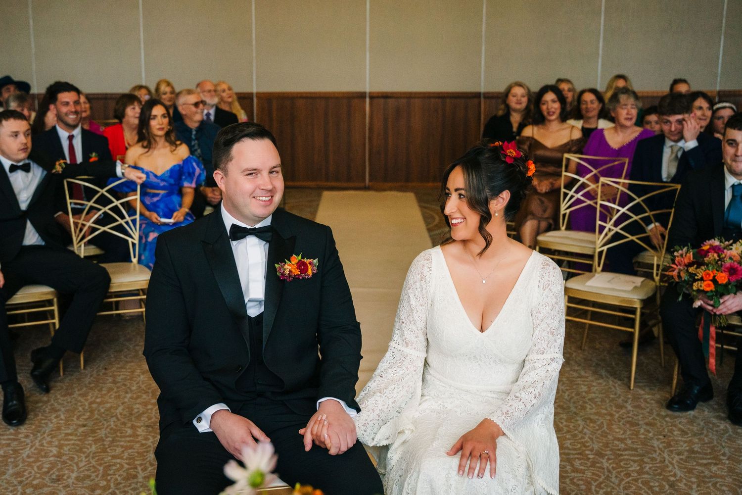 Wedding guests smile and laugh during an entertaining reception moment at an indoor venue. Wedding Photography Trim Castle Ireland