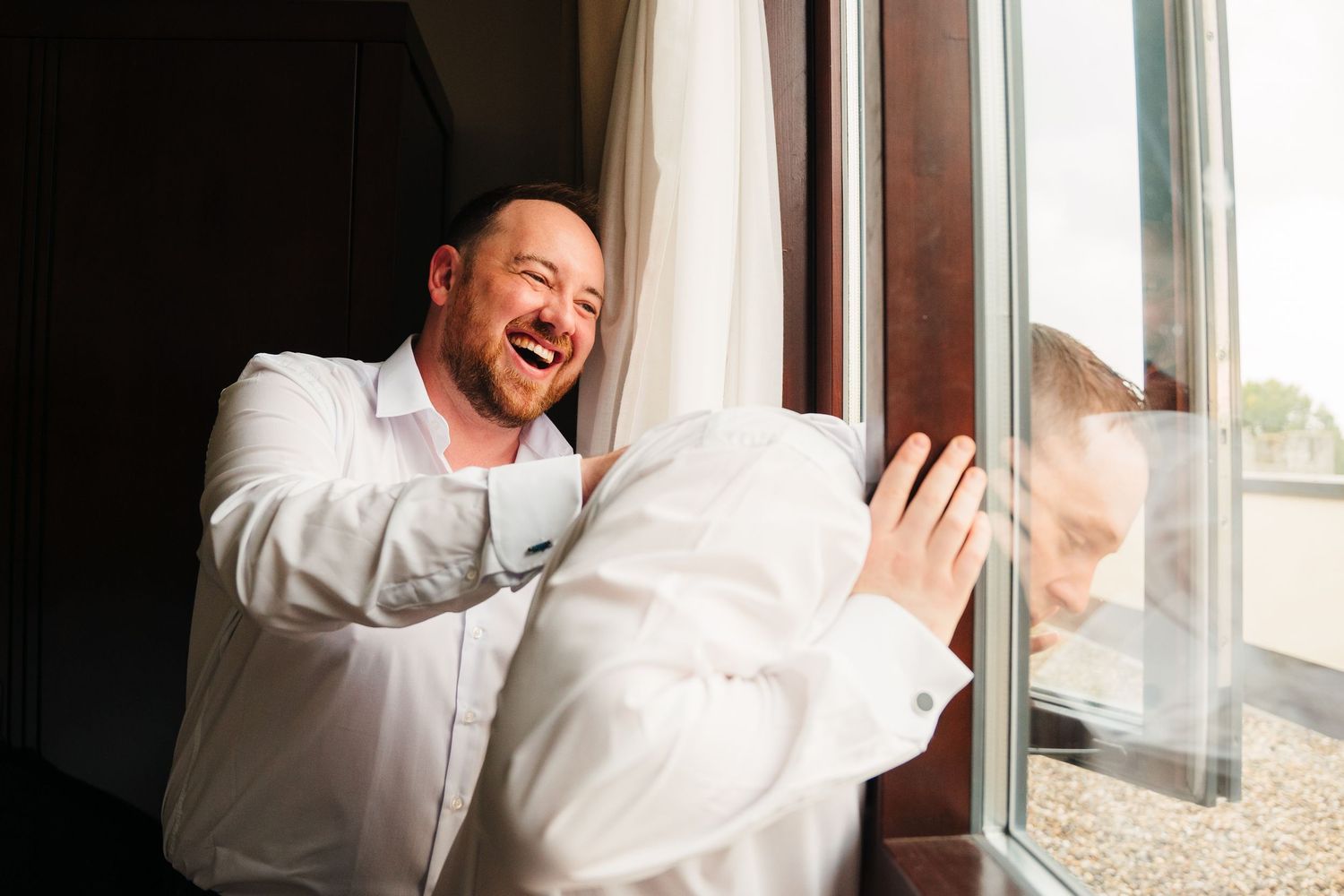 Seven sequential photos show a joyful emotional window scene transitioning from pondering to laughter against sunlit glass. Wedding Photogra