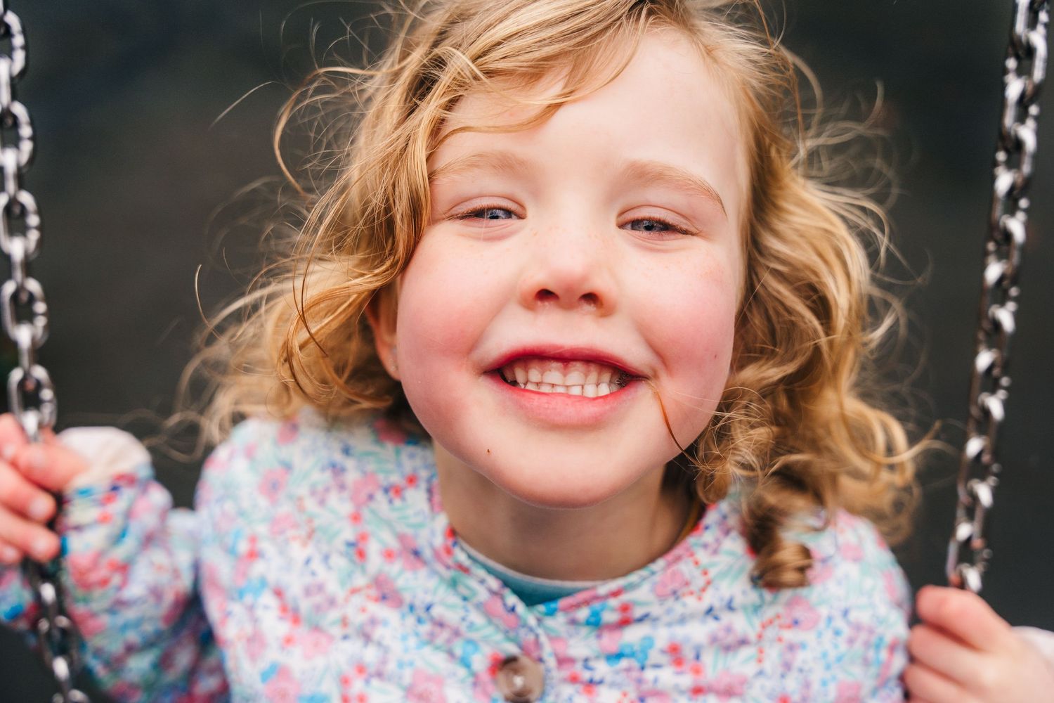Family photographer Dublin Ireland  Pure joy captured on a swing with curly hair flowing.