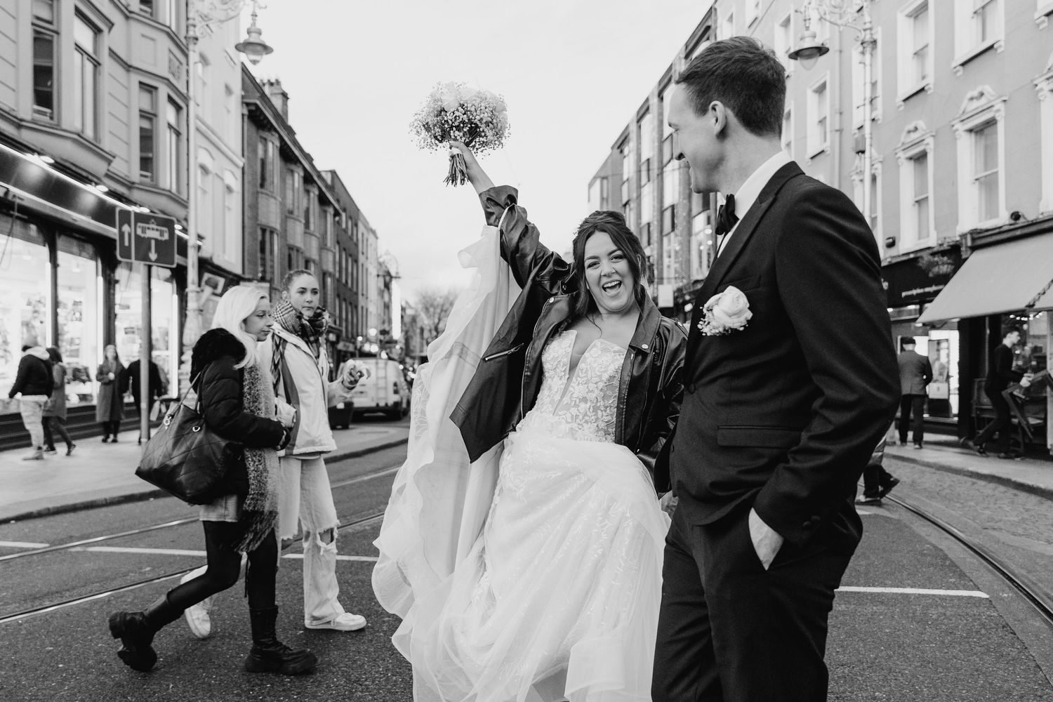 Black and white street photography of joyful wedding celebration in urban setting. Wedding PHOTOGRAPHER Dublin