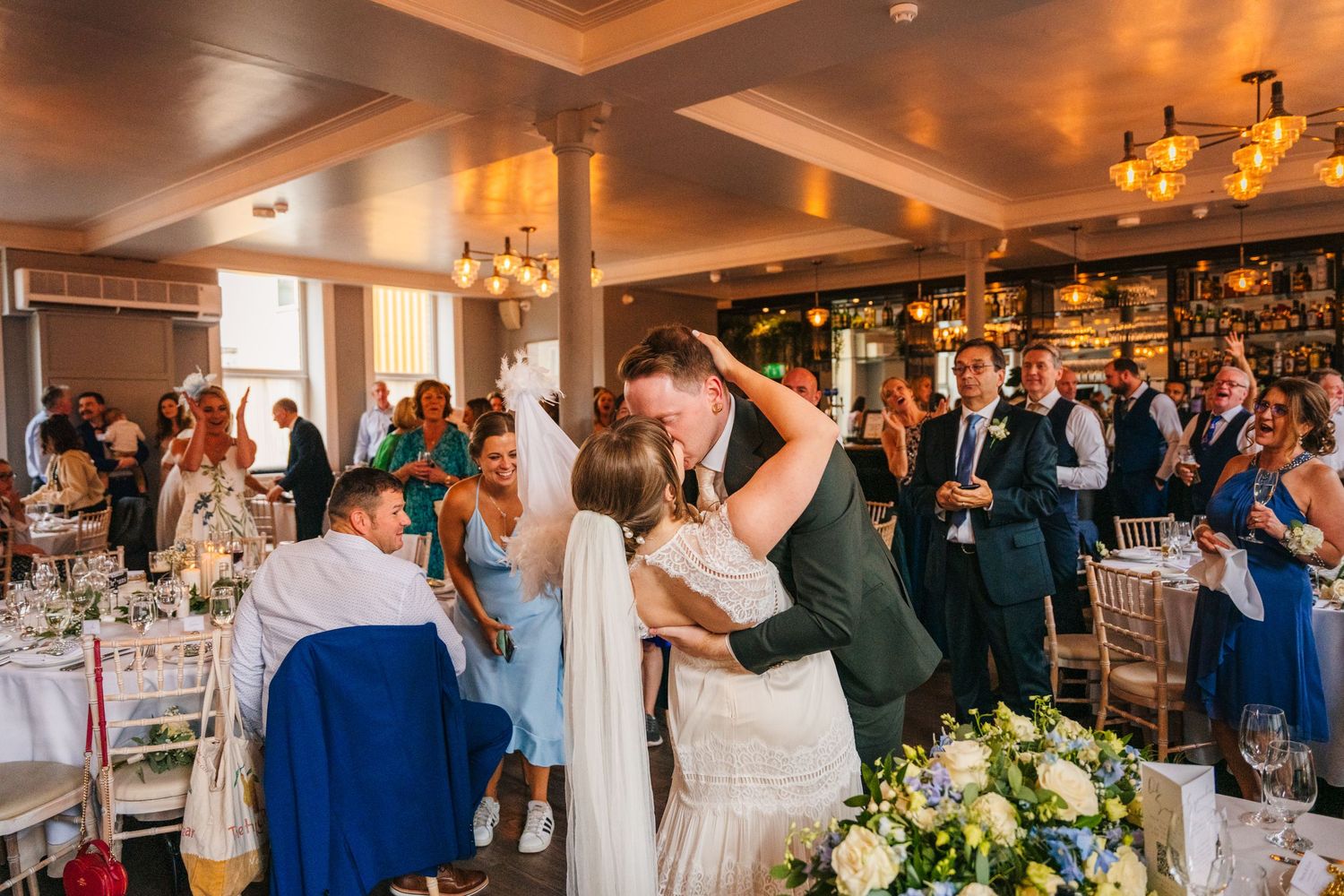 Newlyweds share their first dance surrounded by guests in an elegant reception venue with chandeliers.PHOTOGRAPHER Dublin Ireland Wedding
