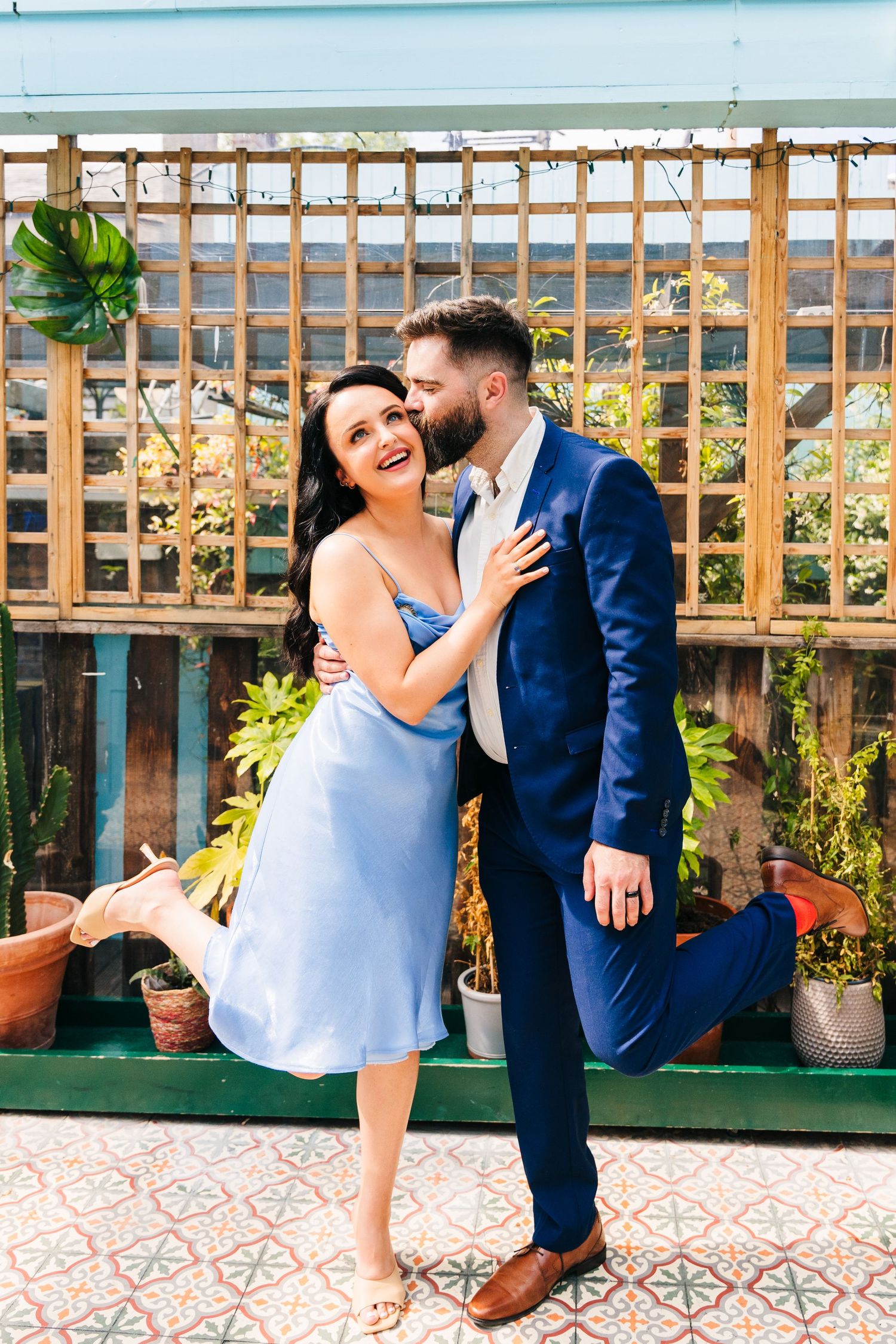 A couple shares a romantic moment in front of a wooden garden trellis on their special day. House Dublin Wedding Photographer