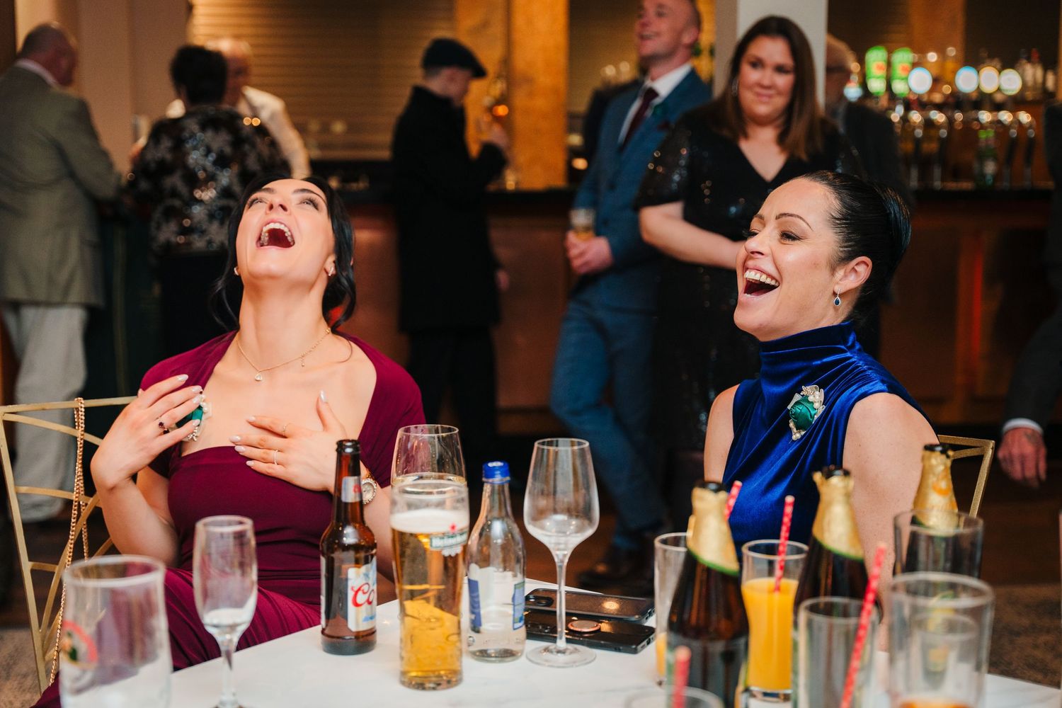 Wedding reception guests laughing and enjoying drinks at dining tables.  Wedding PHOTOGRAPHER Trim Castle