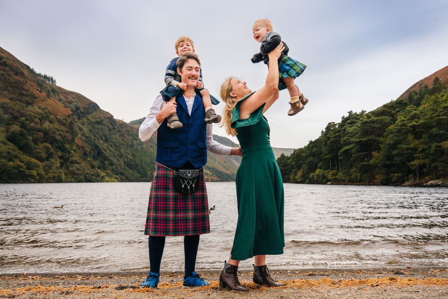 Two people dance together joyfully by a scenic mountain lake on an overcast autumn day.Family photogrAPHER DUBLIN