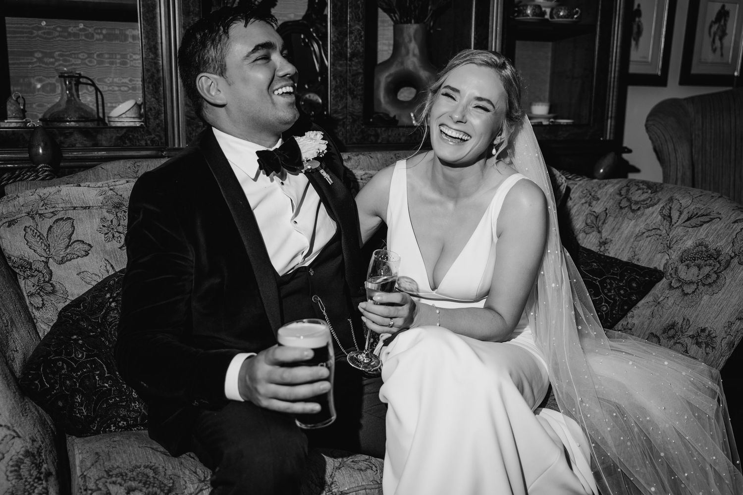 Black and white wedding photos show joyful moments of a couple celebrating with drinks and laughter at their Dublin Wedding photographer