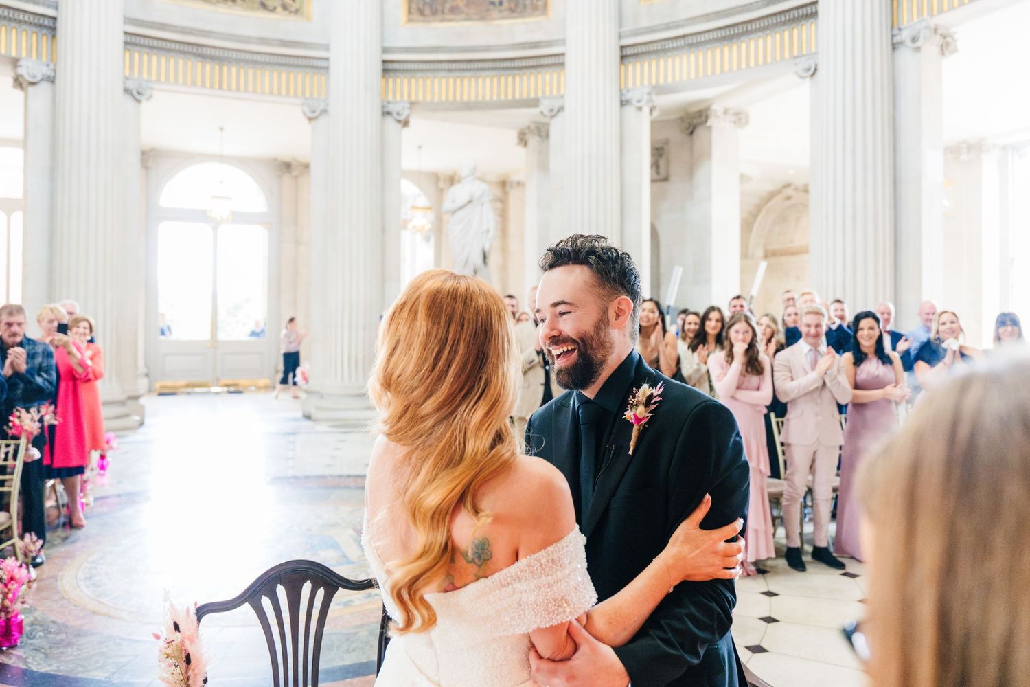 Wedding ceremony in an elegant columned hall with classical architecture and natural lighting.  city hall dublin wedding photos
