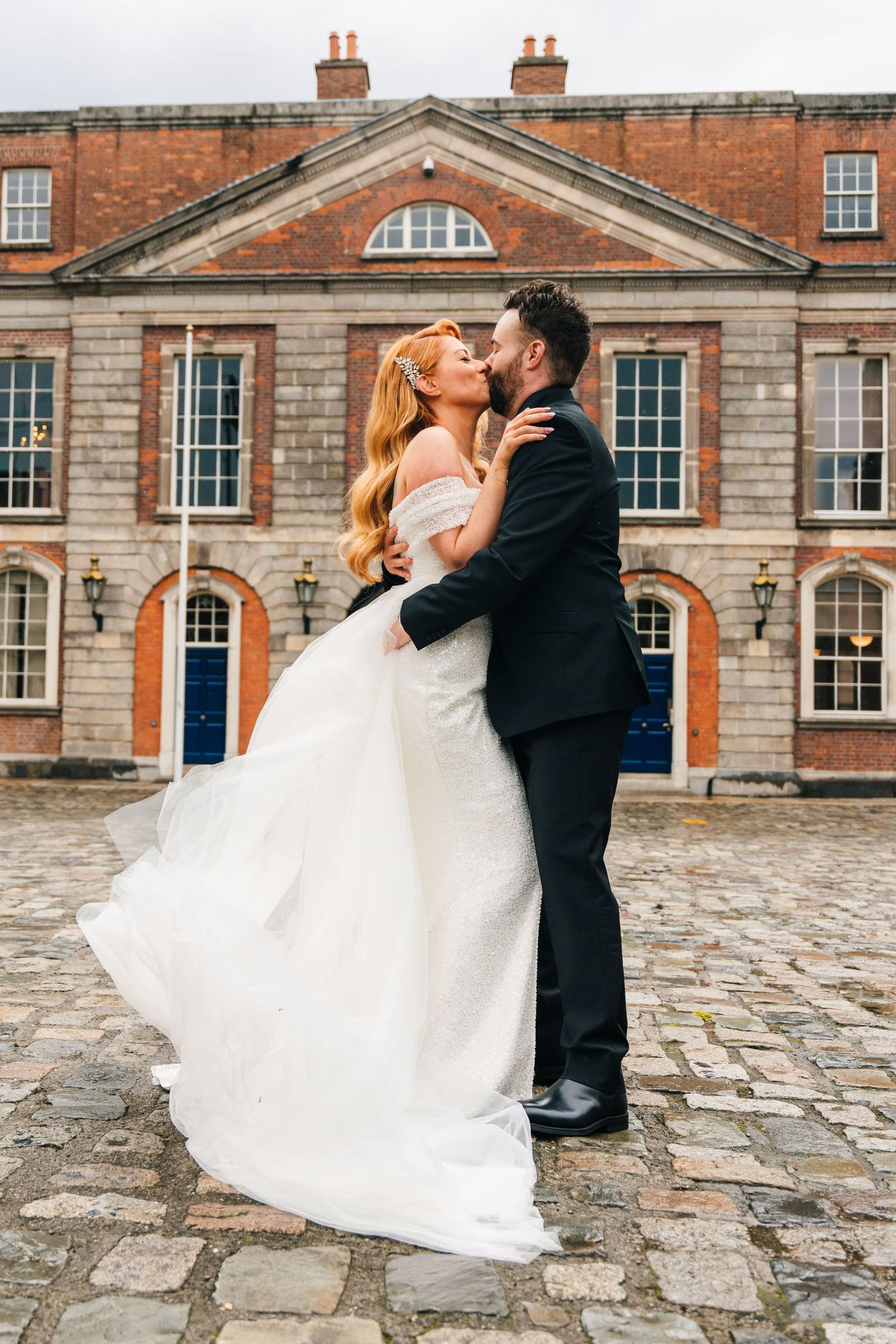 Romantic wedding portrait in front of historic brick mansion with cobblestone courtyard.  city hall dublin wedding photos