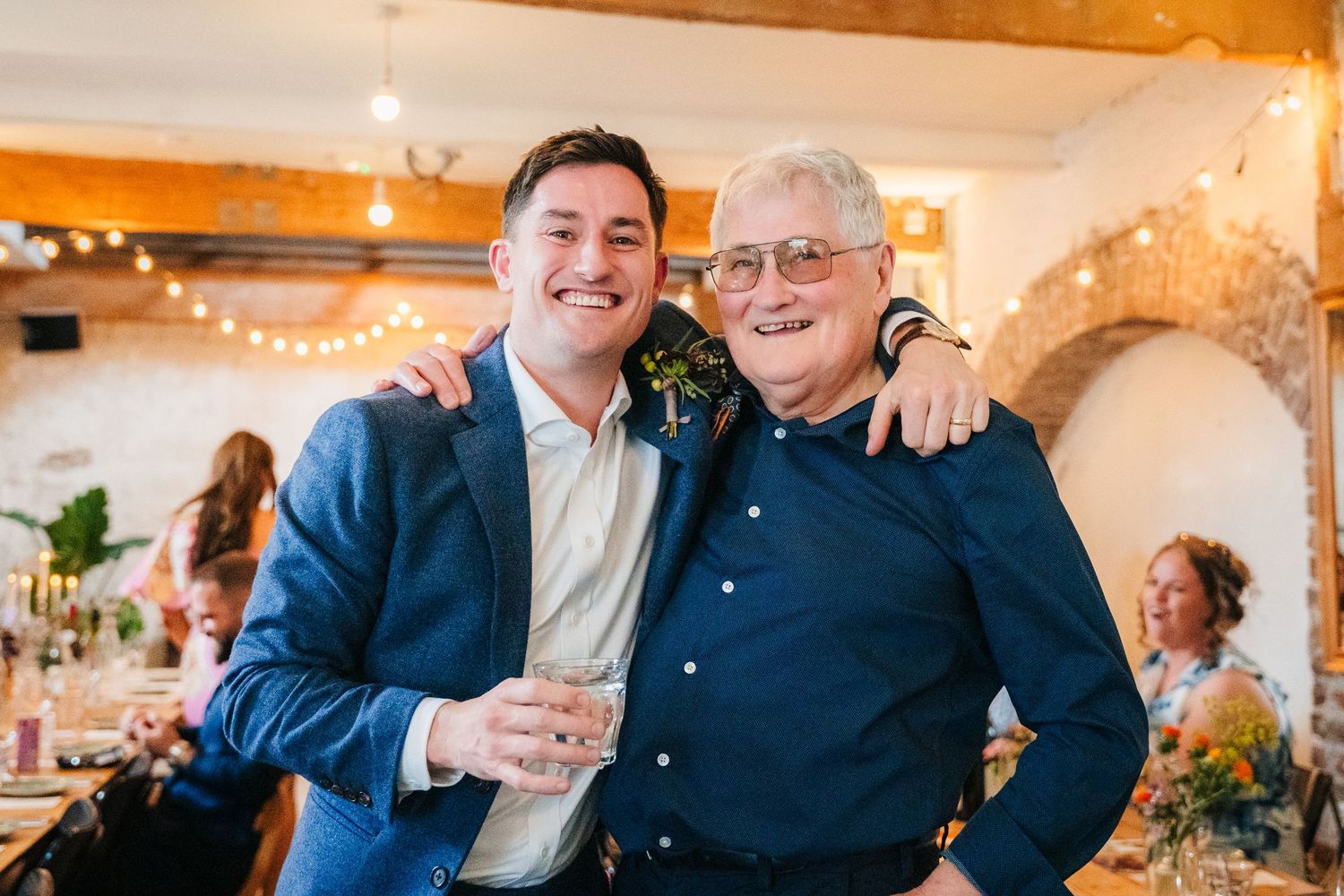 Wedding reception celebration showing guests enjoying themselves in a warmly lit indoor venue.Same sex wedding PHOTOGRAPHER Dublin