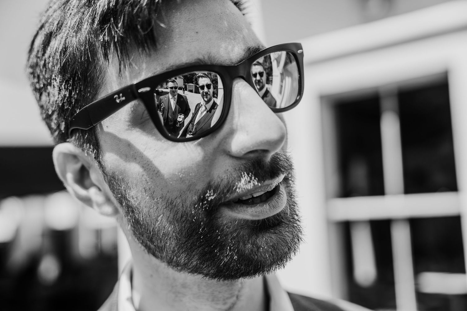 Poulaphouca Wedding photographer wicklow  Closeup profile view of someone wearing sunglasses and sporting a beard outdoors.