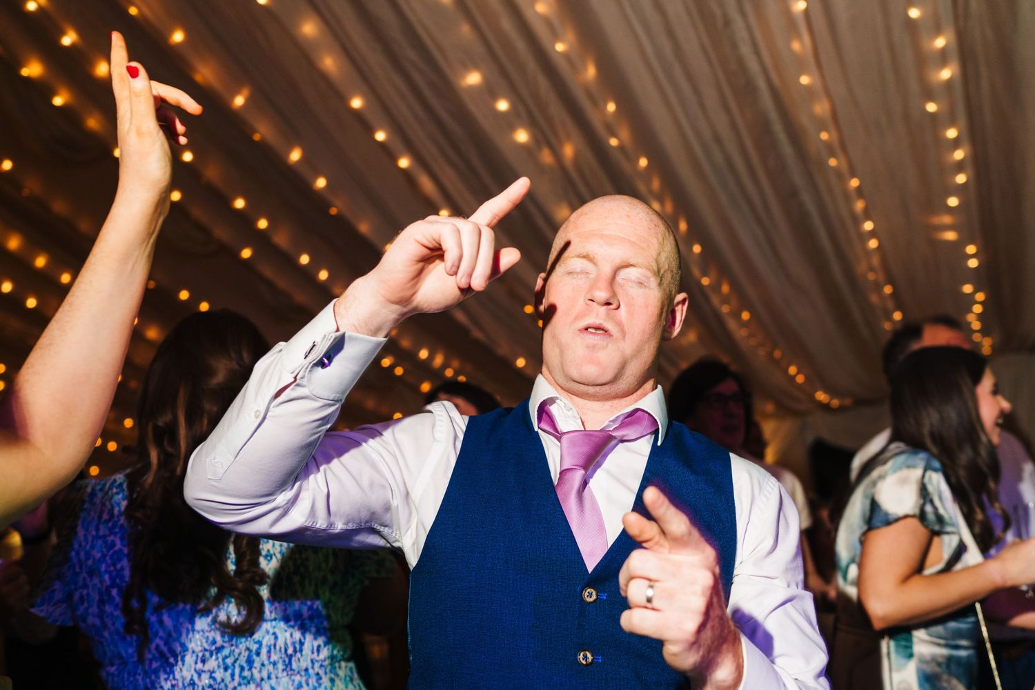 Castle Leslie Wedding PhotographPeople dancing and celebrating at a wedding reception with twinkle lights overhead in a festive atmosphere.