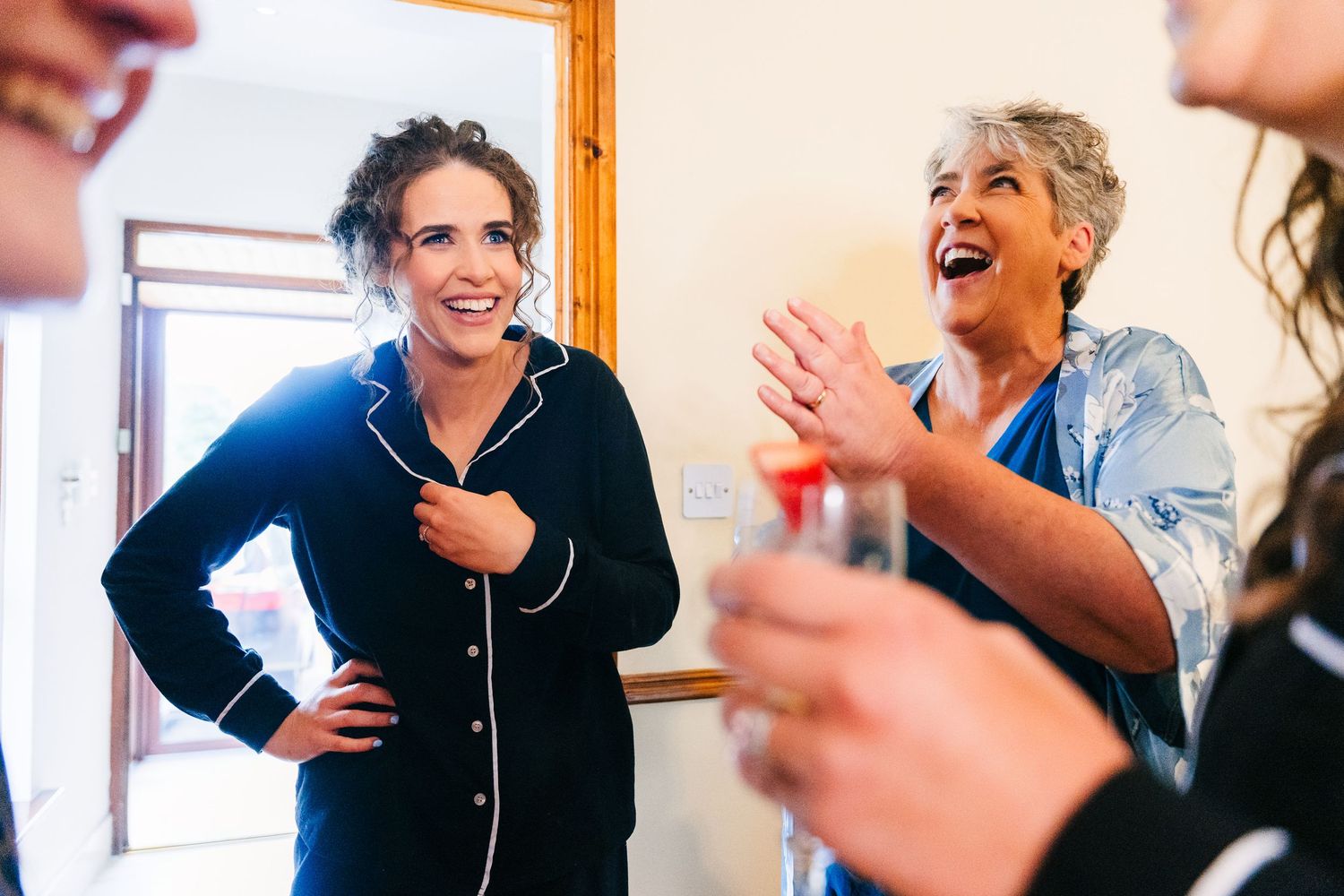 A group of people laughing and smiling together during a joyful social gathering indoors. Millhouse slane wedding photographer dublin