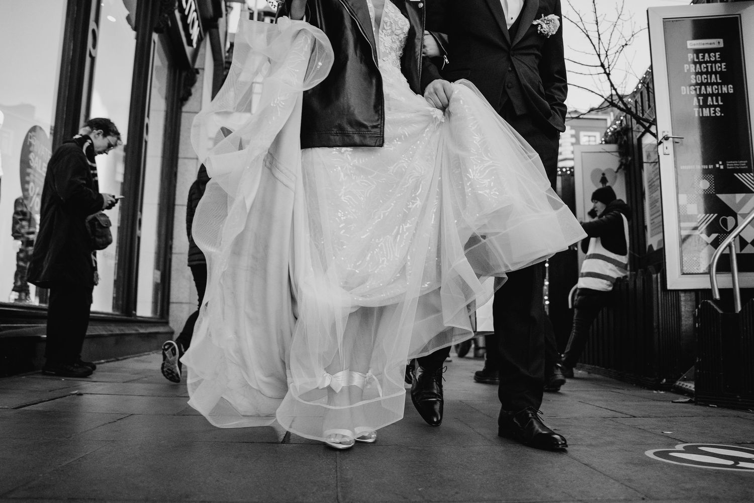 A wedding couple walks together through an elegant corridor in black and white. Wedding PHOTOGRAPHER Dublin