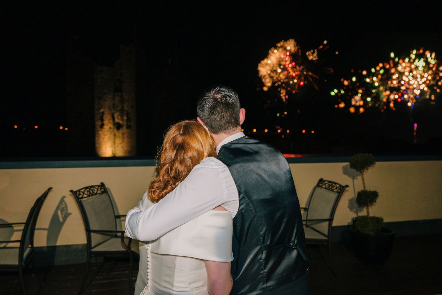 Couple watching fireworks display together during their wedding celebration.  Wedding PHOTOGRAPHER Trim Castle