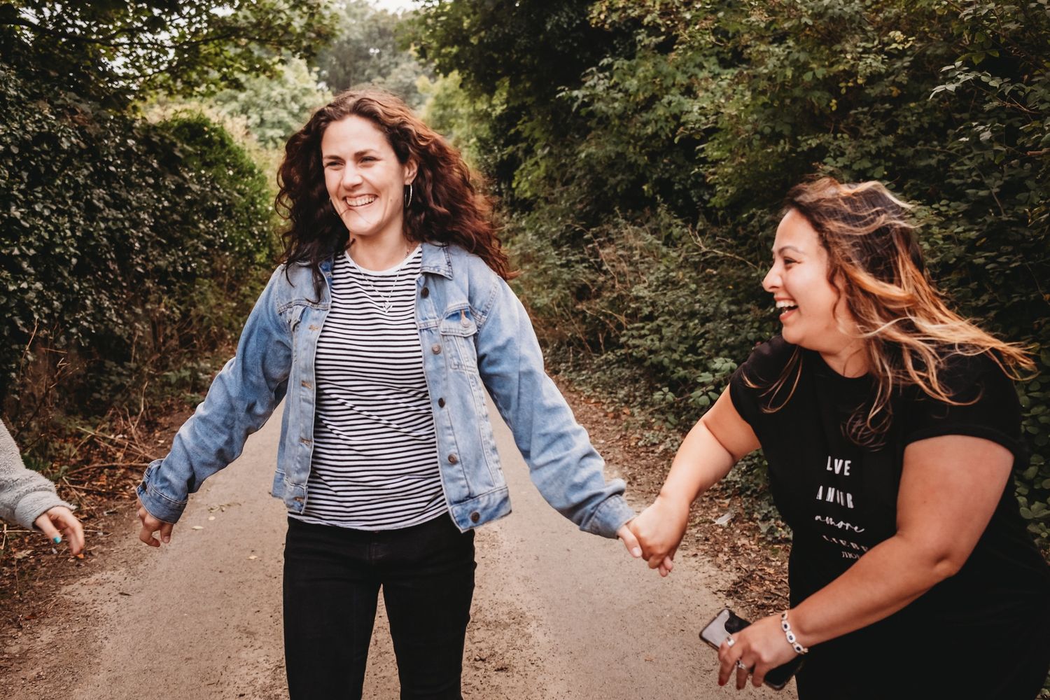 A couple holds hands while walking through a wooded trail on a sunny autumn day. deirdre rusk photography - wedding photographer dublin meat