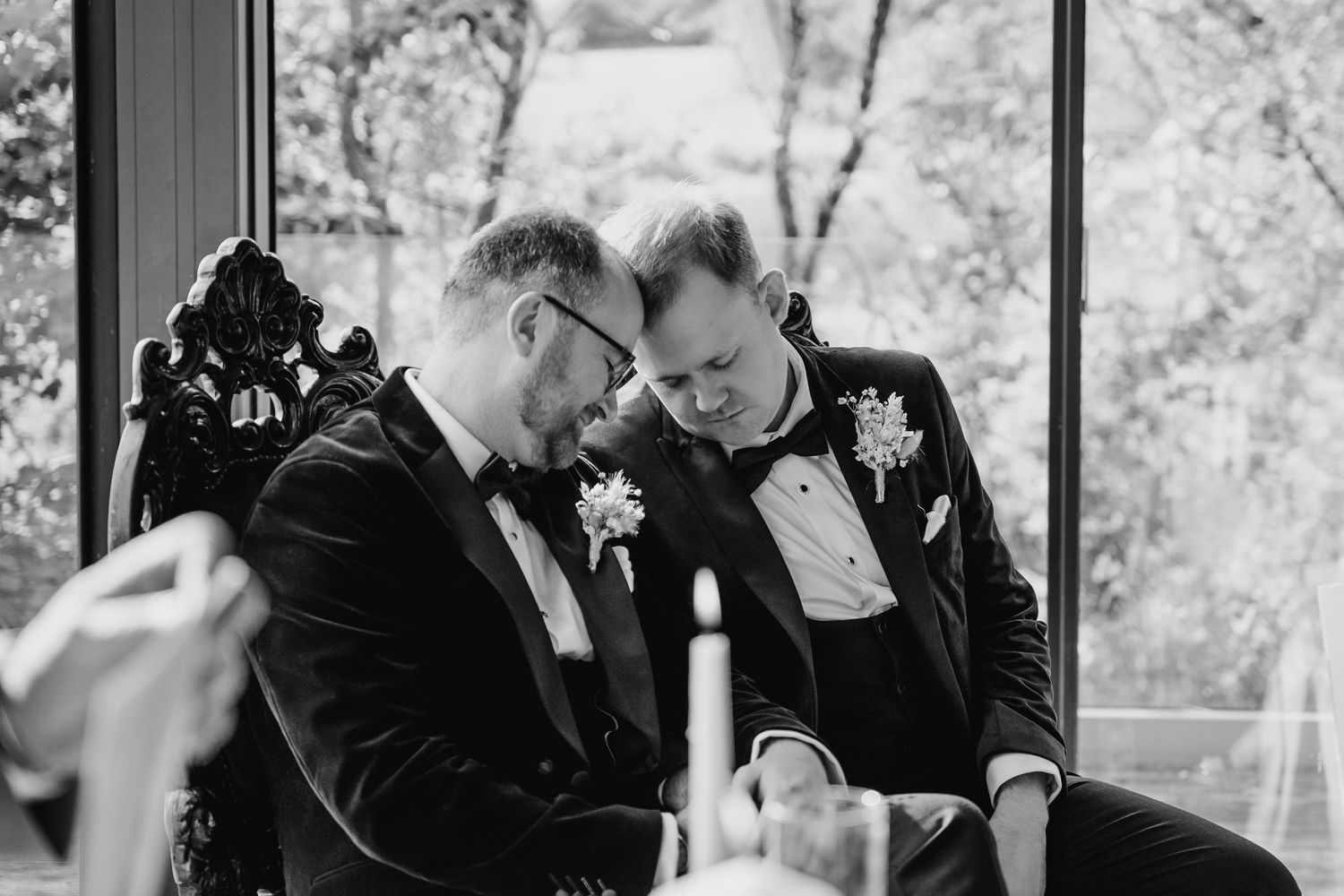 Intimate black and white moment between couple in tuxedos during wedding ceremony. LGBTQ Ashley Park Wedding Photographer