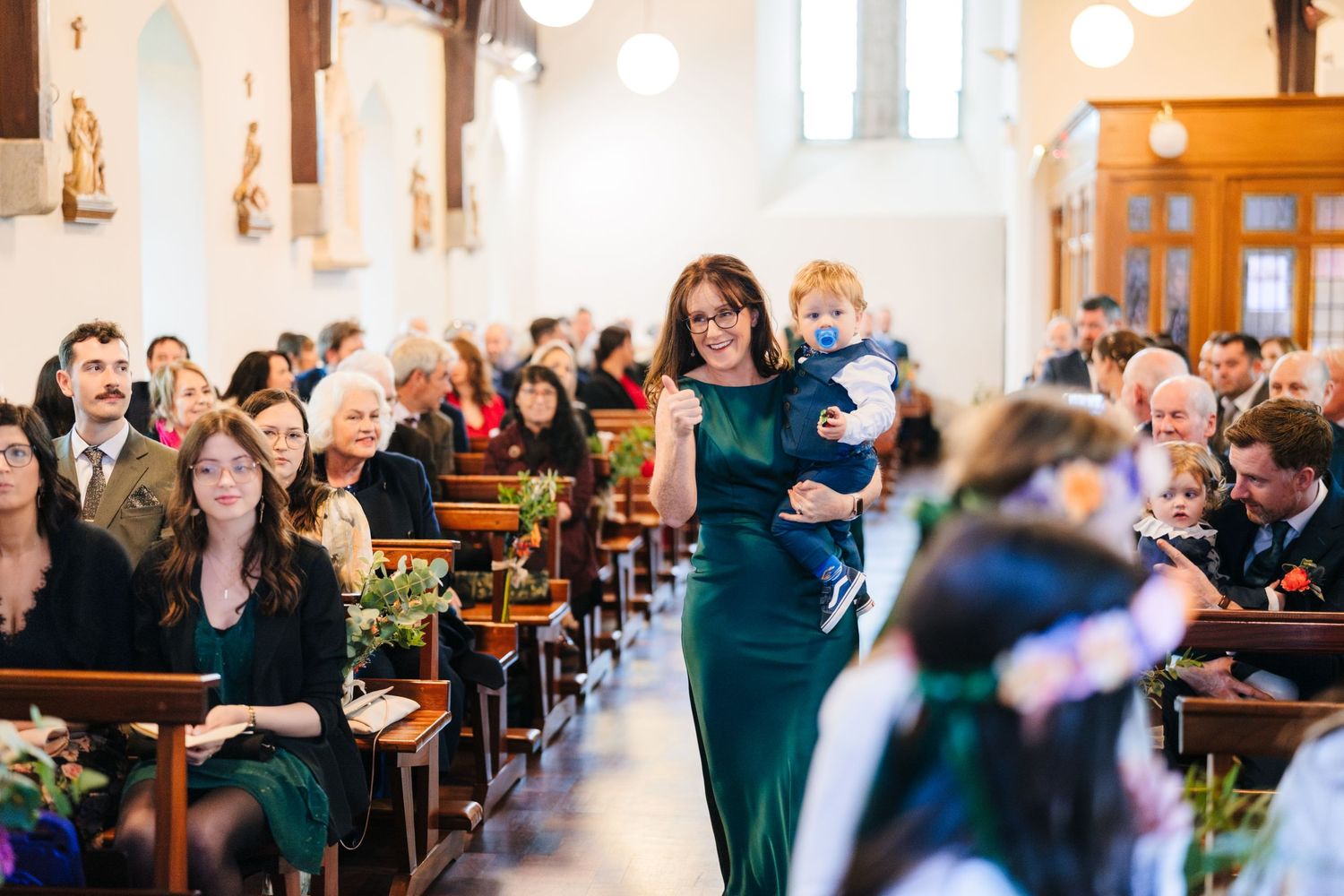 Wedding ceremony in a church with emerald green accents and natural lighting.