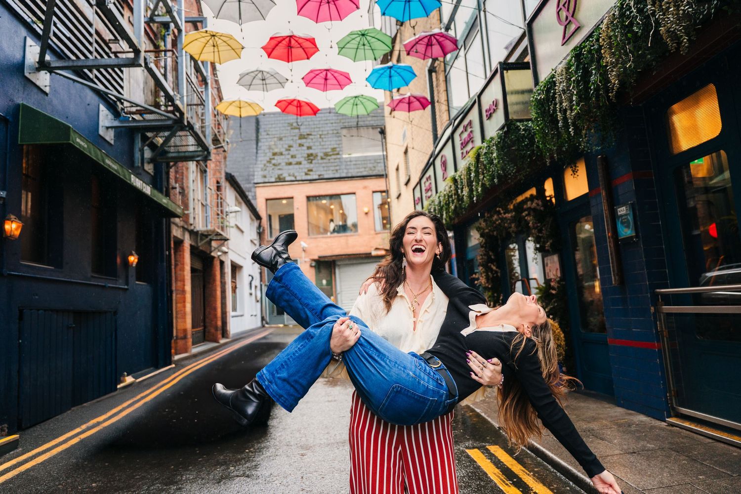 Colorful umbrellas hang overhead in an urban alley creating a vibrant canopy. professional headshots dublin photographer