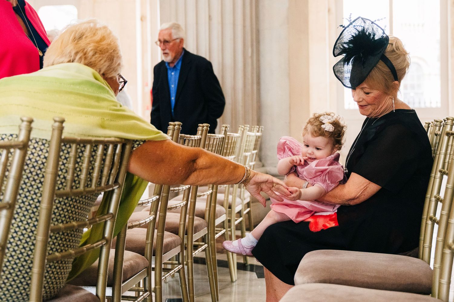Wedding guests seated in elegant chairs at a formal indoor reception venue.  city hall dublin wedding photos