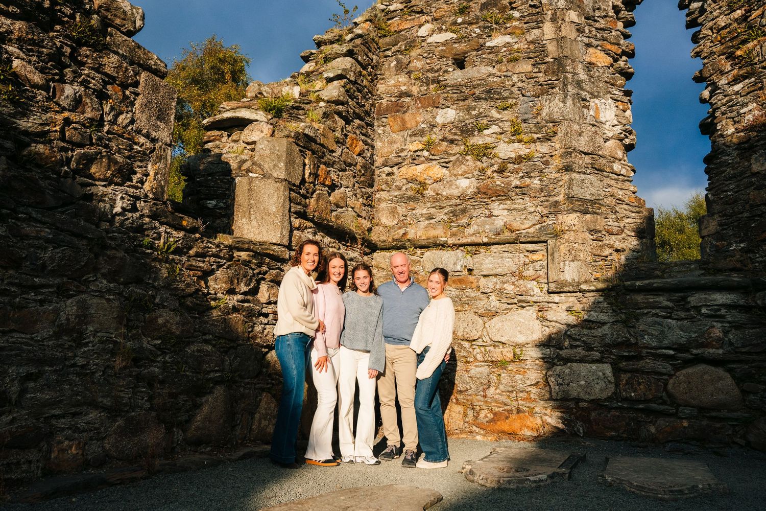 Family photographer Ireland Dublin A series of candid moments captured against an old stone wall backdrop during a photo session.
