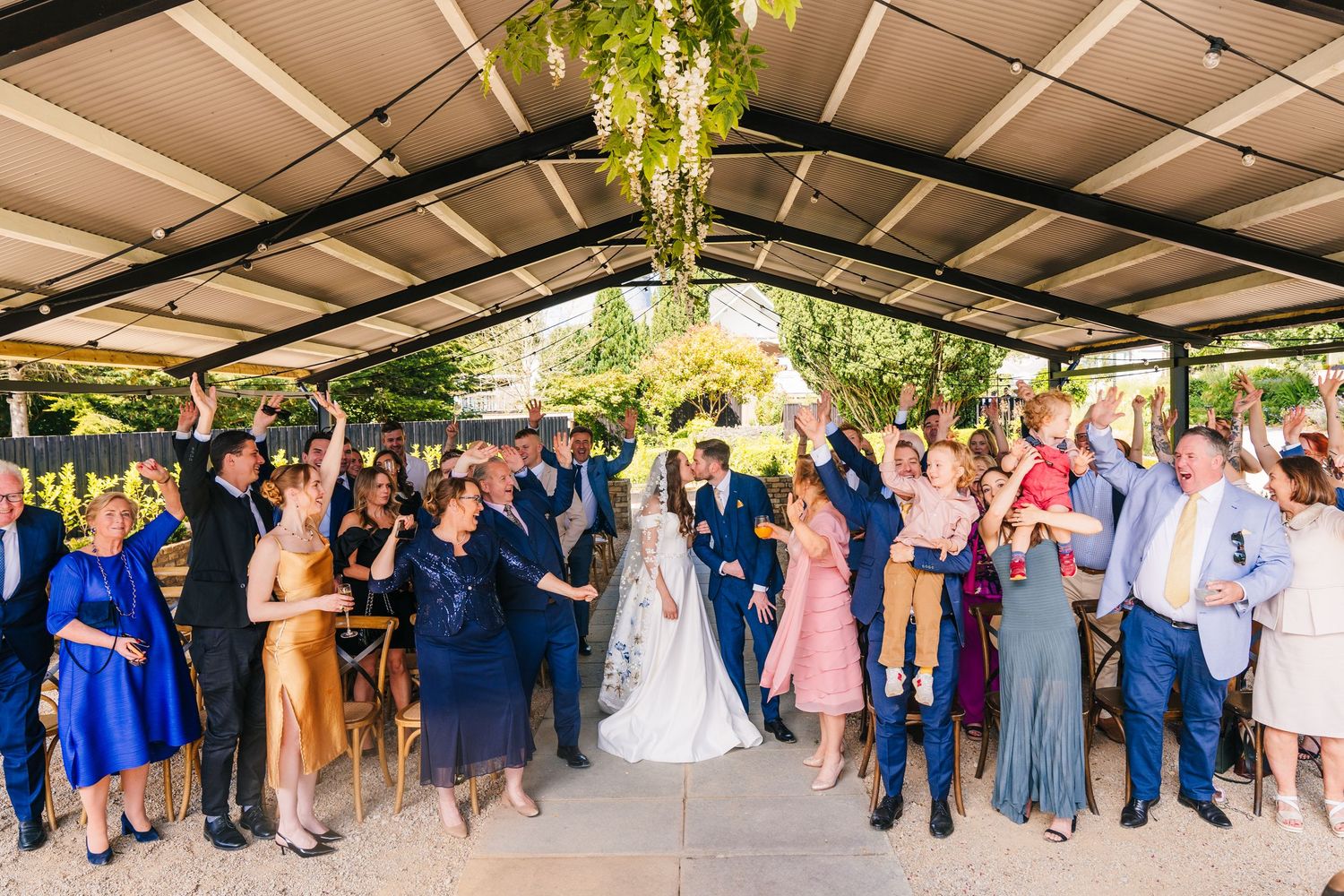 Poulaphouca Wedding photographer wicklow  Wedding guests celebrate under a covered outdoor venue during a reception.