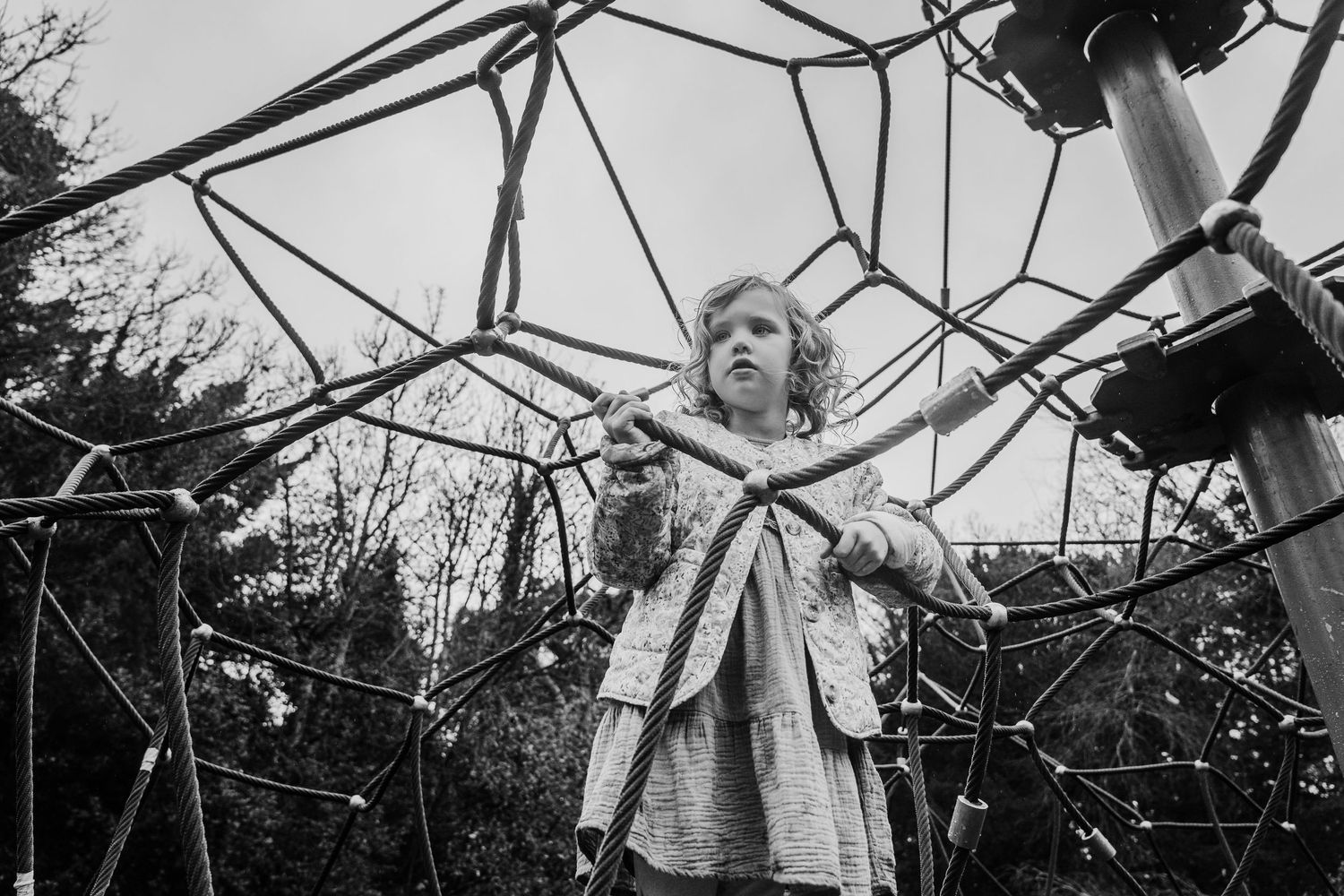 Family photographer Dublin Ireland Multiple motion shots of playground equipment with wooden beams and metal bars against a bright sky.