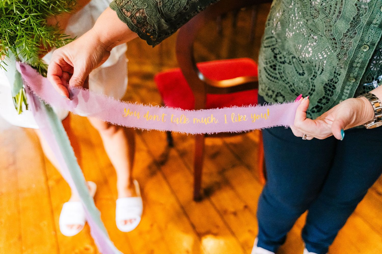 Close-up of hands rolling pink cookie dough in colored sugar while baking holiday treats on a wooden surface.Millhouse slane wedding photogr