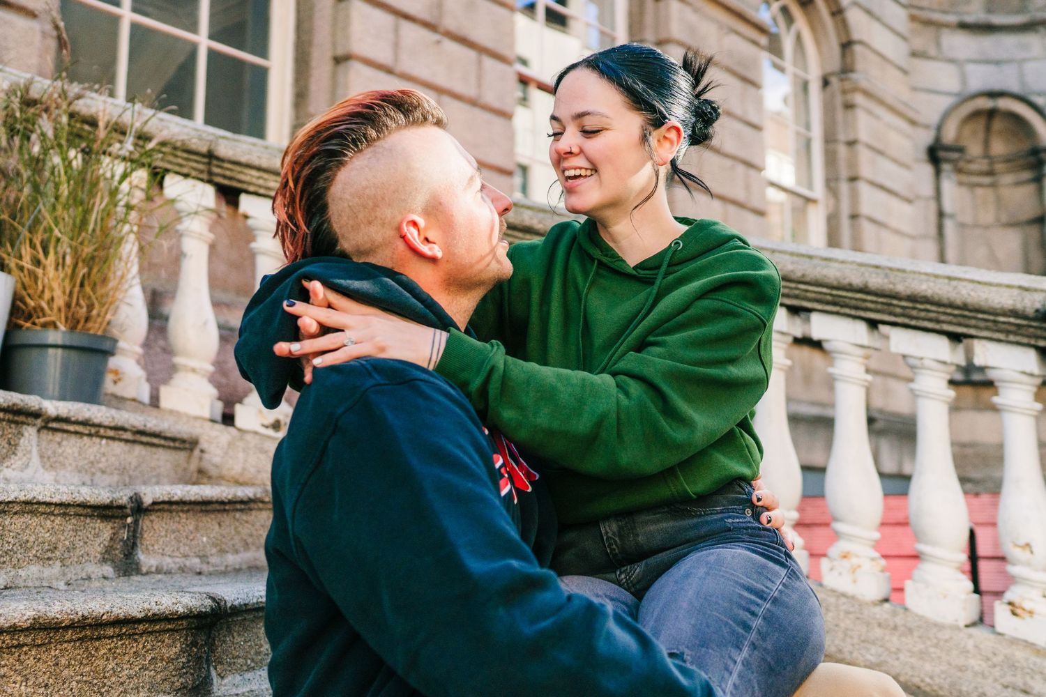 A couple sharing an embrace on stone steps outside a historic building. PHOTOGRAPHER Dublin Ireland