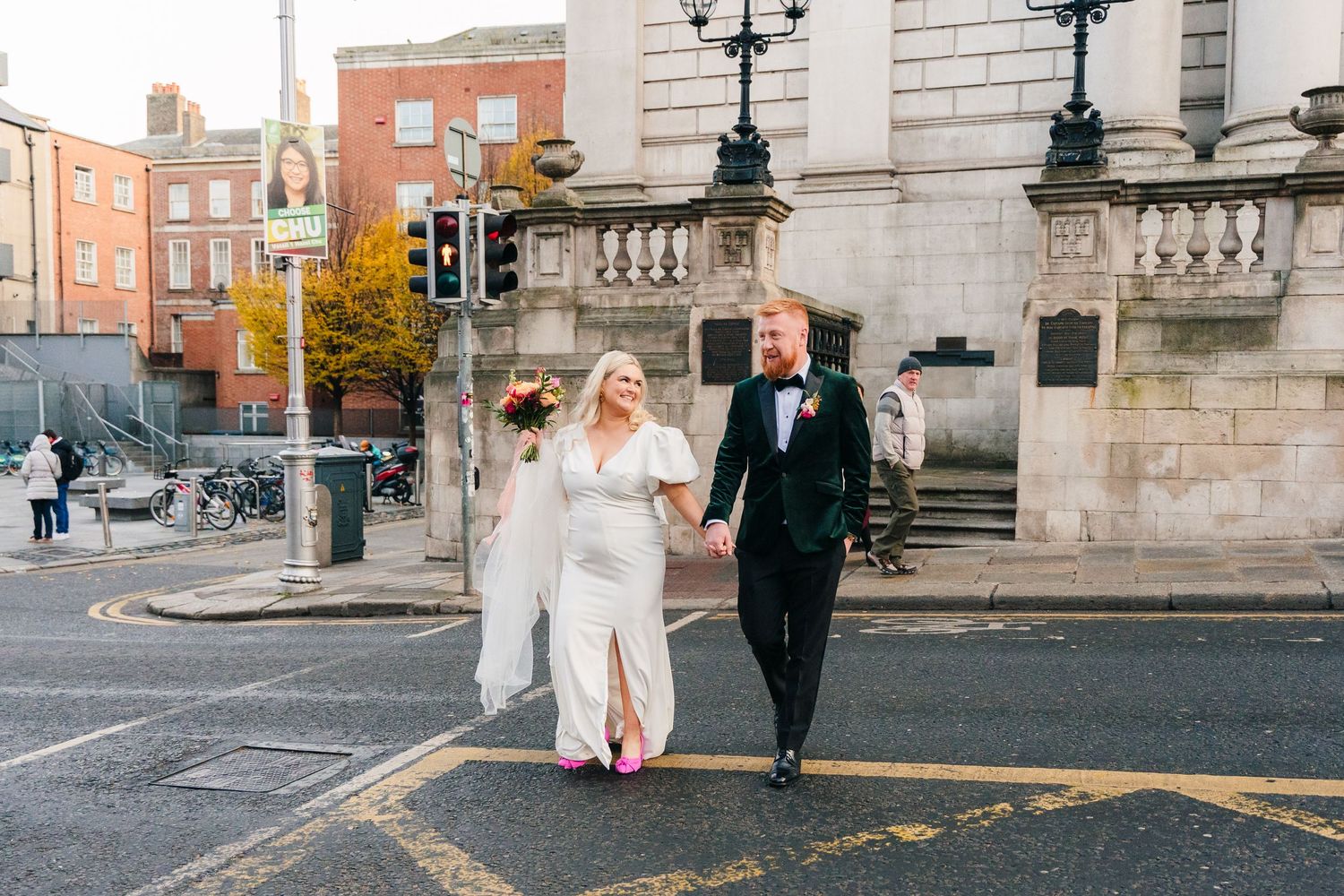 A couple walks together on a Dublin city street during autumn with historic buildings in the background. City Hall Dublin Photographer