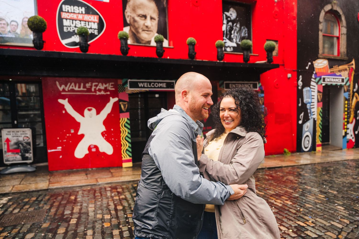 An intimate engagement photography session in front of a red wall in Edinburgh's historic district. Proposal Dublin Photographer
