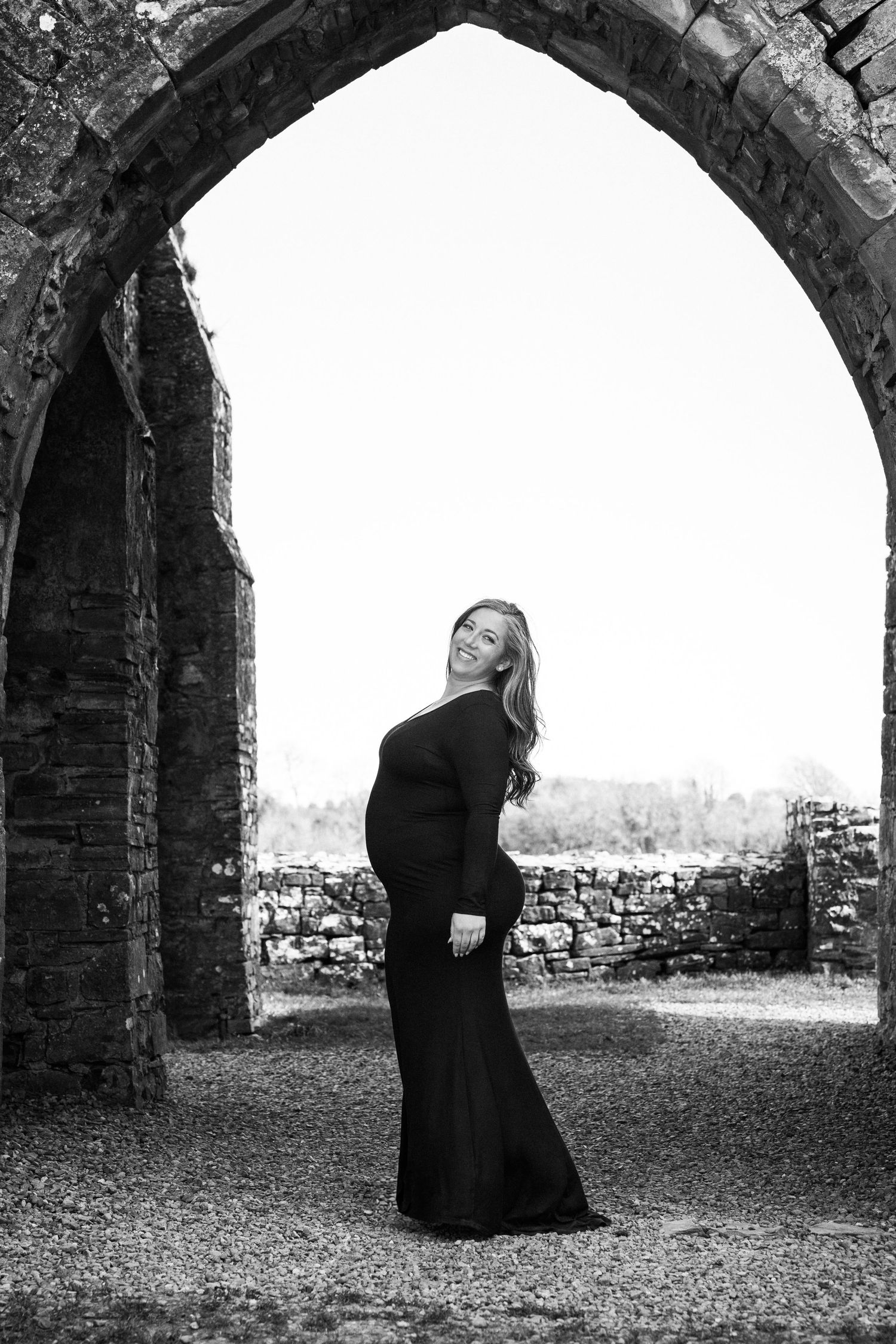 Black and white sequence showing figures moving through a large stone archway. Family PHOTOGRAPHER Dublin
