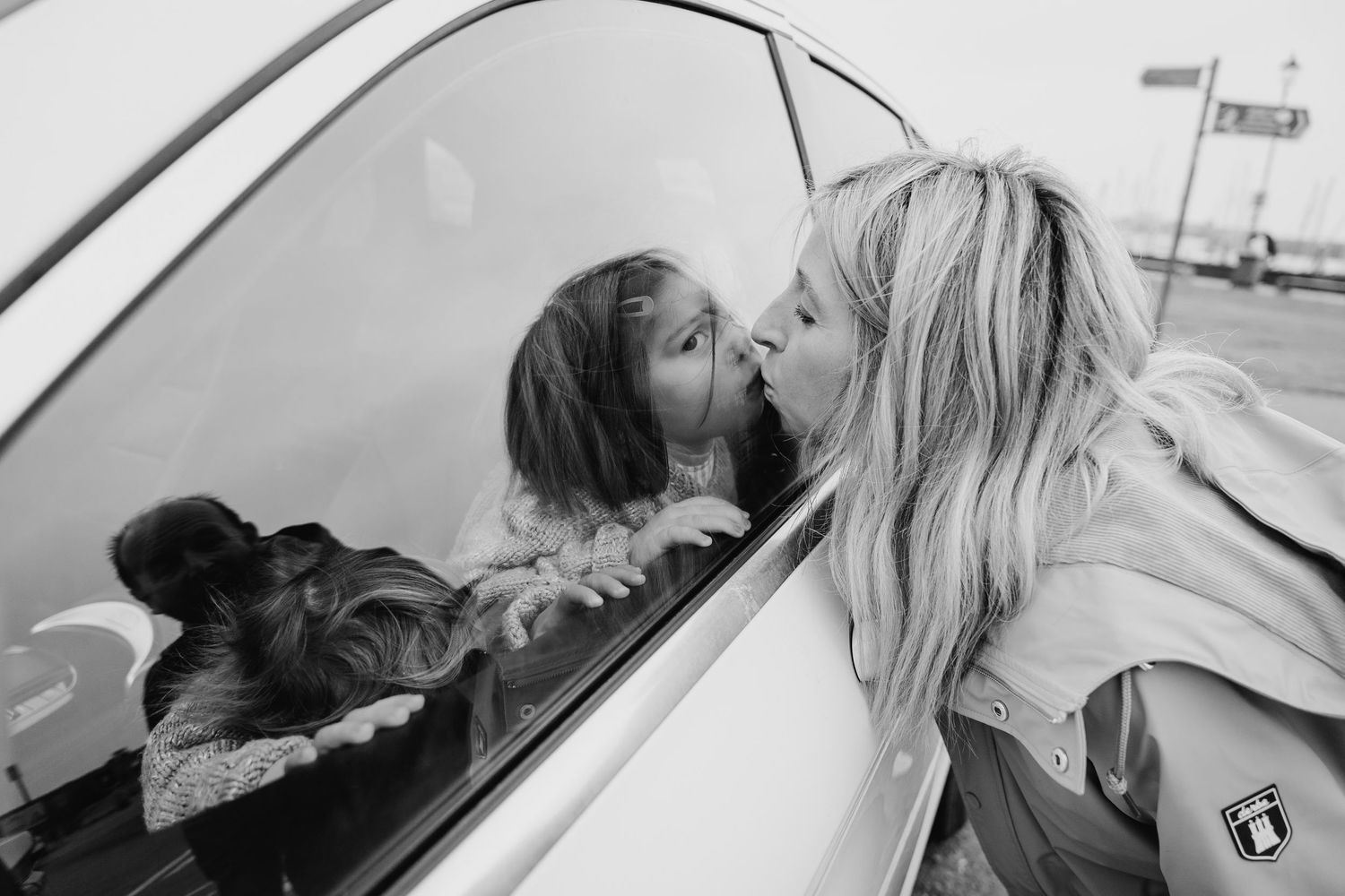 A tender moment reflected in a car window on an overcast day. PHOTOGRAPHER Dublin