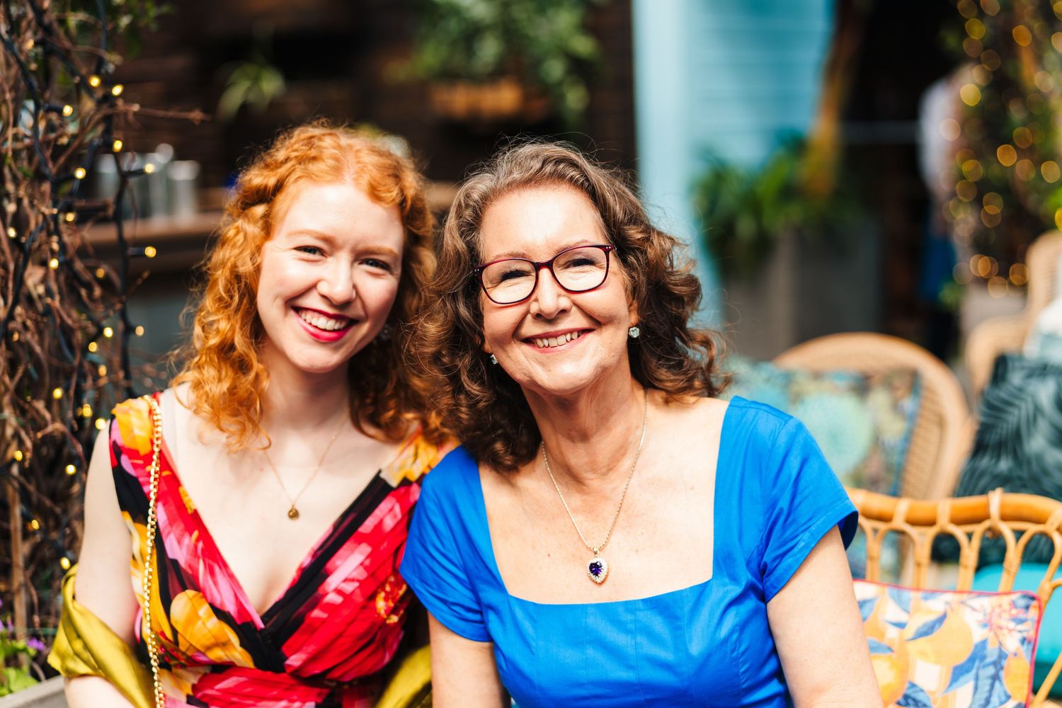 Two women in colorful dresses enjoying an outdoor gathering with smiles and laughter. House Dublin Wedding Photographer