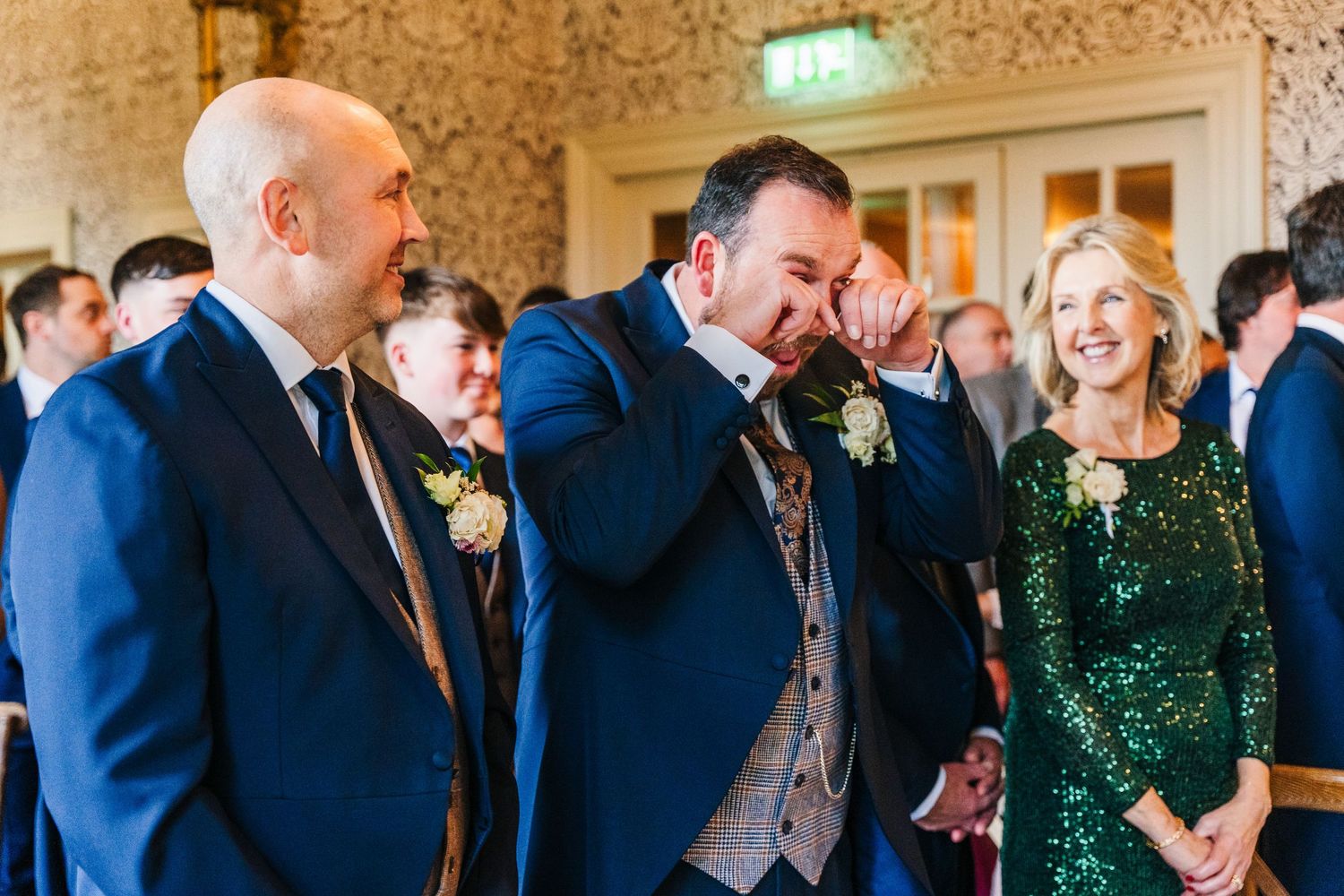 Guests in formal attire mingle and socialize during an elegant reception under ornate chandeliers.  Virginia Park Lodge Wedding Photographer