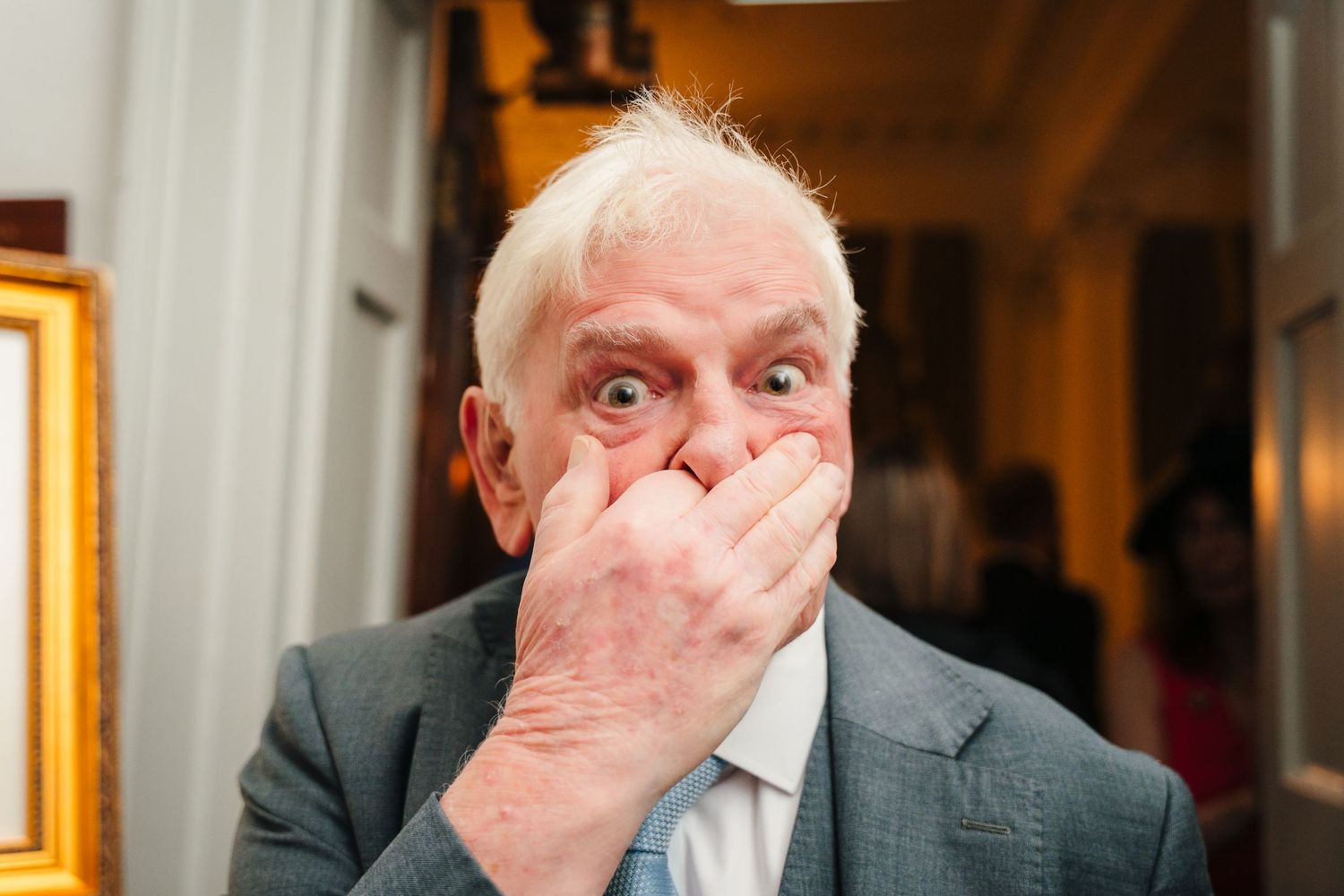 Formal event guest in grey suit covering mouth in surprise. Stephens green club dublin Wedding photographer