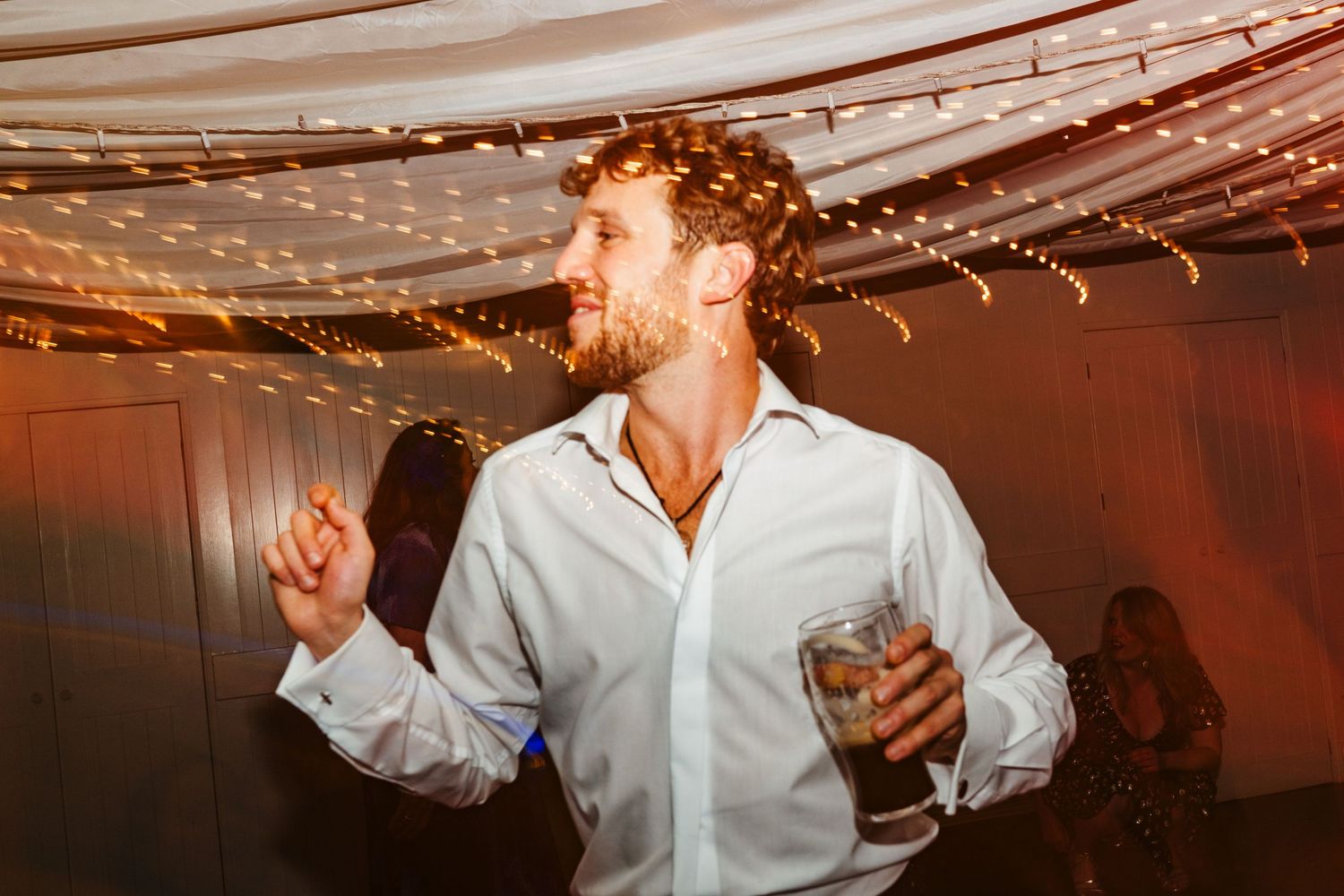 Wedding reception dance floor illuminated with warm string lights and romantic atmosphere.  Virginia Park Lodge Wedding Photographer Cavan D