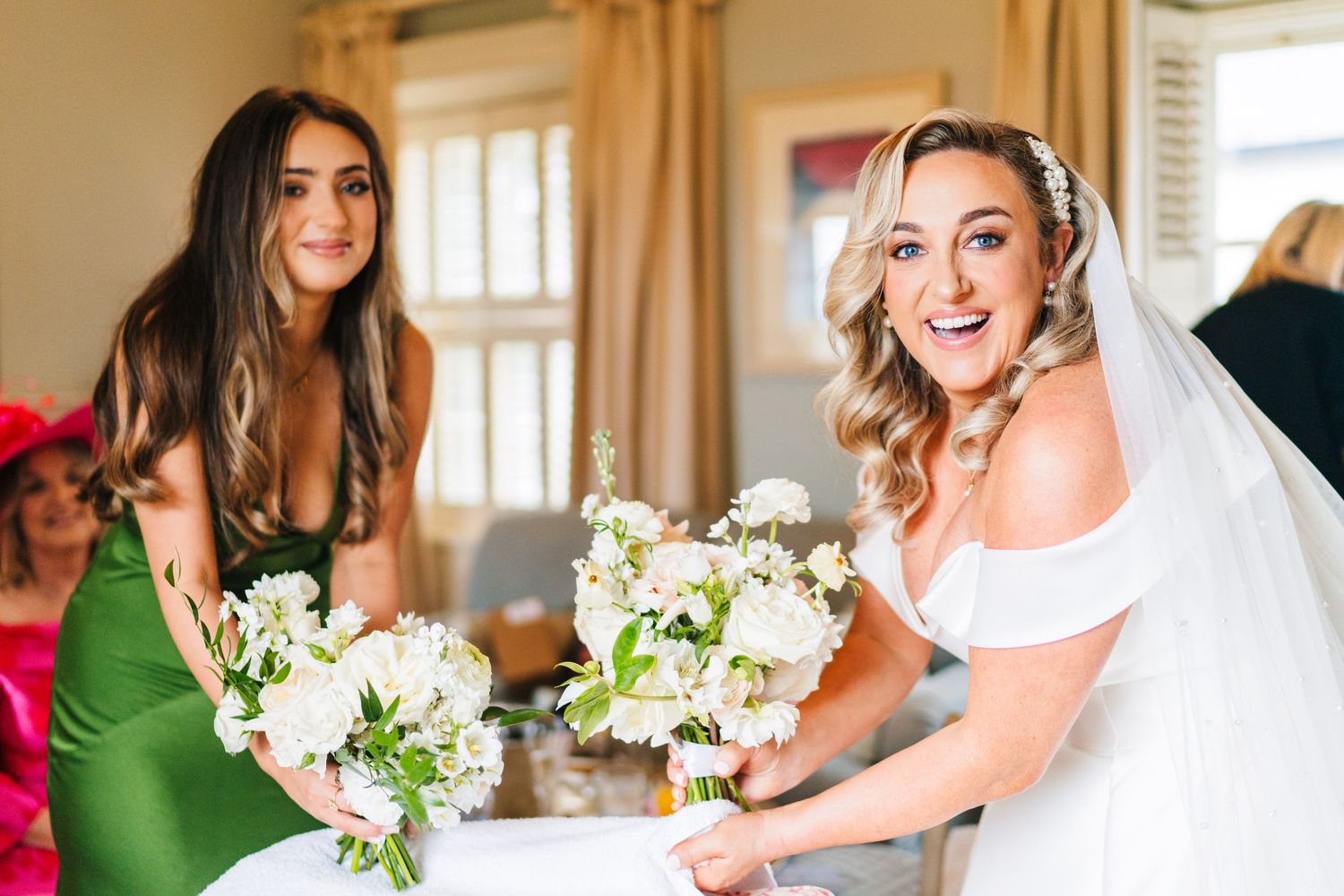 Wedding party members in emerald green dresses share joyful moments with the bride in a white gown.  Virginia Park Lodge Wedding Photographe