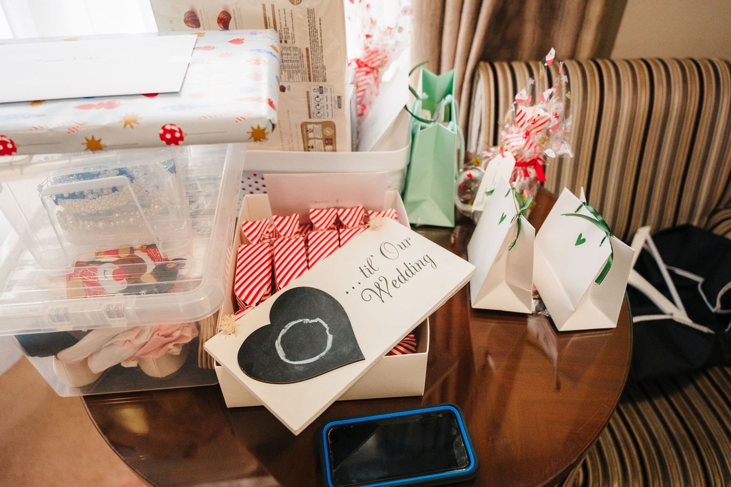 Scattered Valentine's Day cards and crafting supplies lay across a wooden table for DIY handmade card making. Trim Wedding Photographer