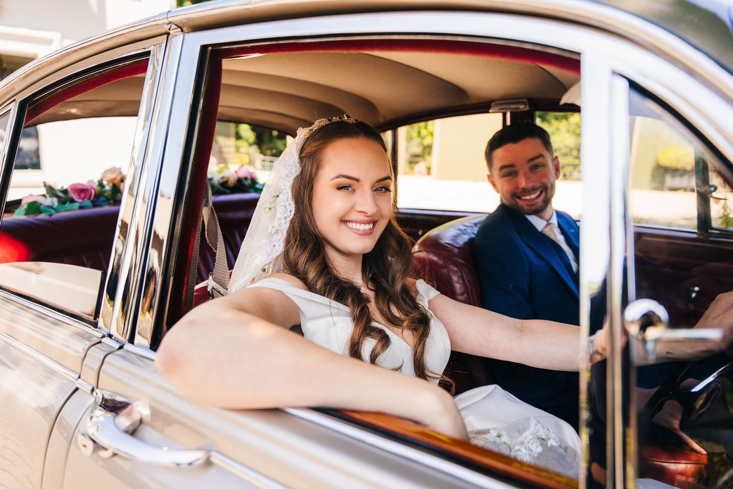 Poulaphouca Wedding photographer wicklow  Happy couple seated in classic car on their wedding day.