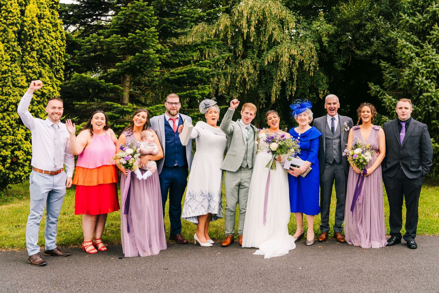 Millhouse slane wedding photographer dublin Wedding party group photo with bridesmaids in purple dresses on garden path.