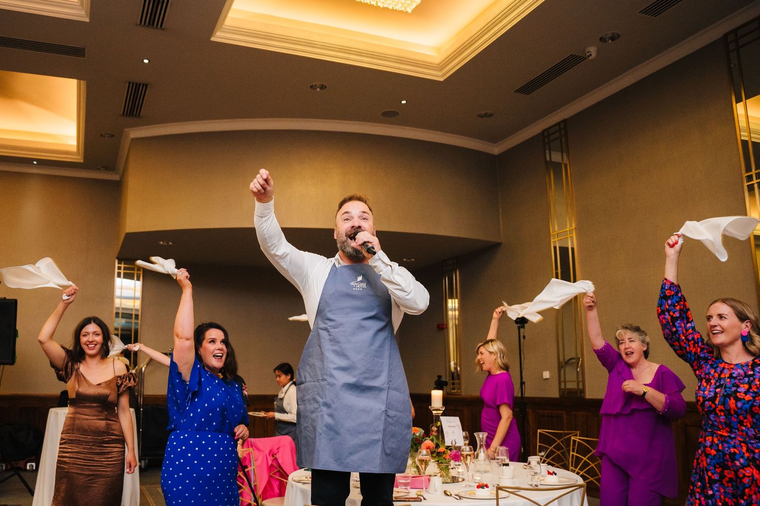 Sequence of guests dancing and celebrating in warm-lit reception hall with uplighting.Wedding Photography Trim Castle Ireland