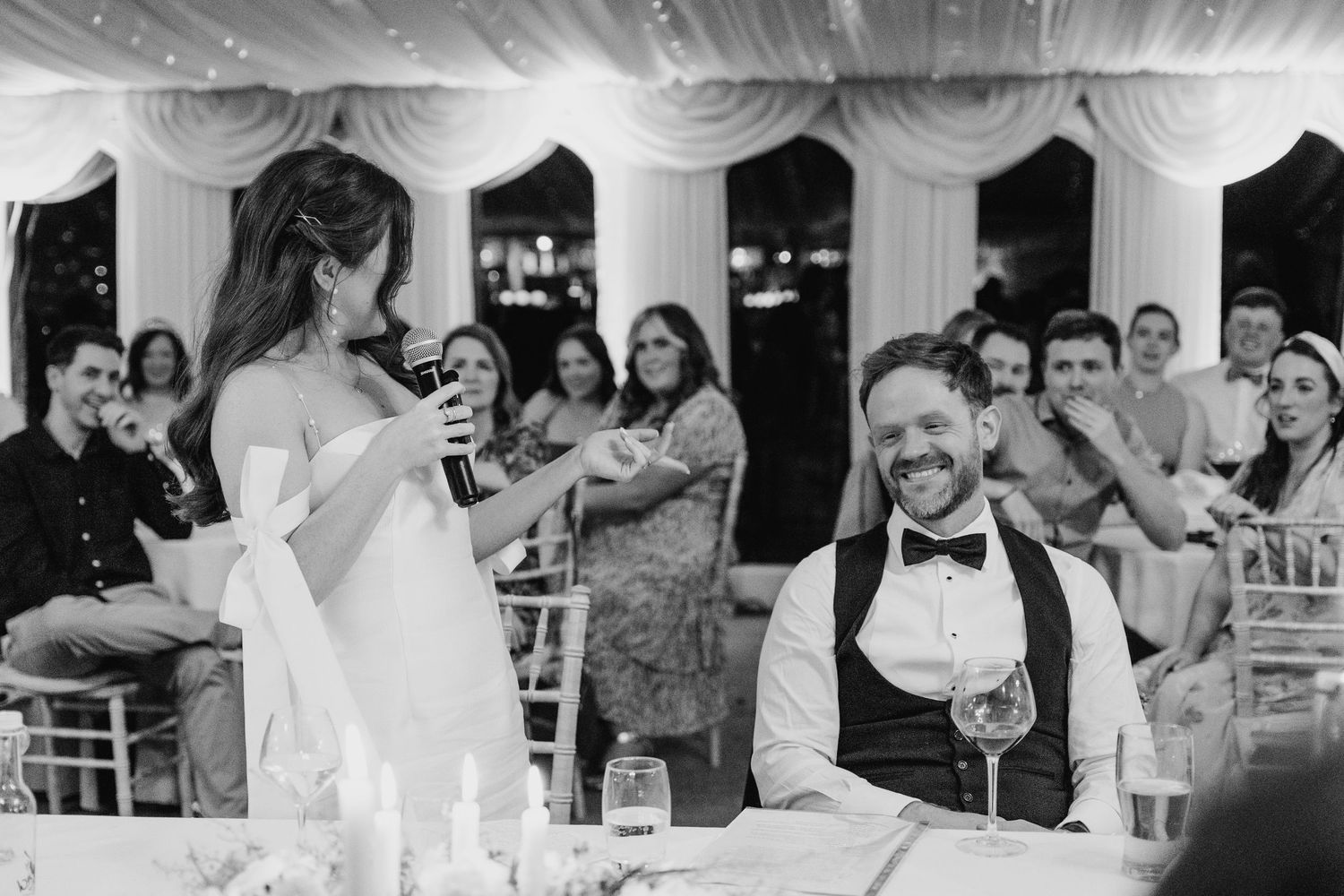 Castle Leslie Wedding Photographer Dublin Guests watch attentively during wedding speeches in a decorated reception tent.