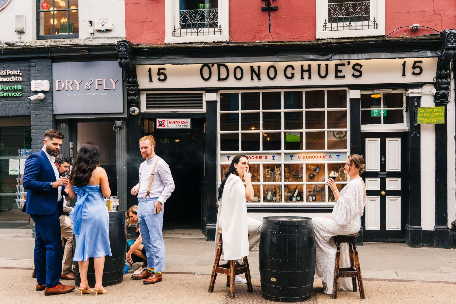 Wedding party gathers outside traditional Irish pub O'Donoghue's on a sunny day. House Dublin Wedding Photographer