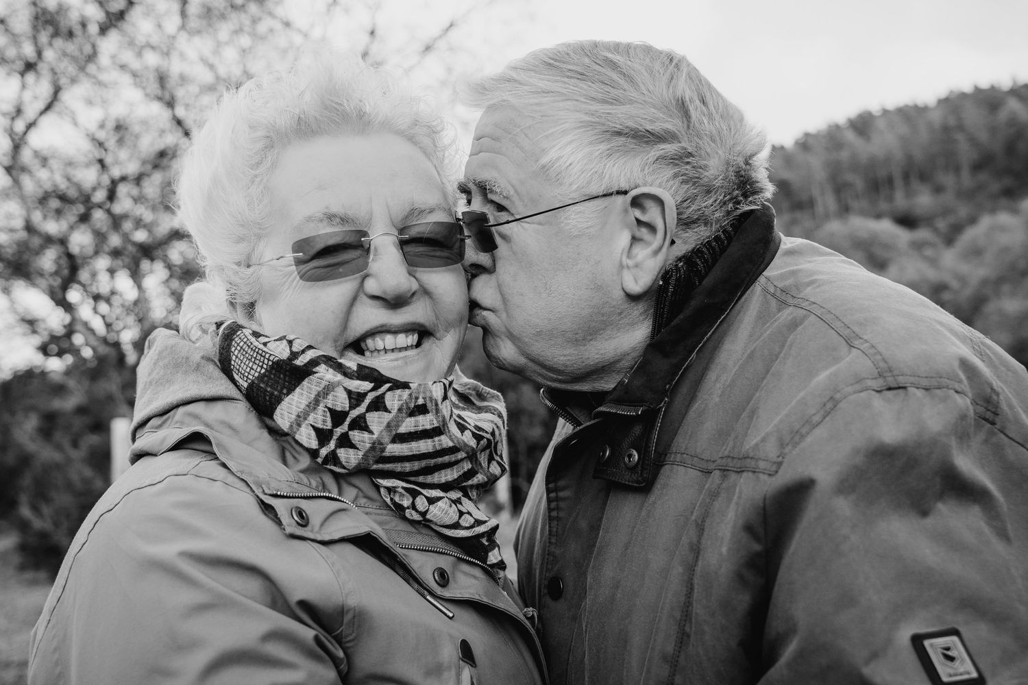A black and white photograph showing an affectionate moment between a senior couple outdoors. PHOTOGRAPHER Dublin ireland