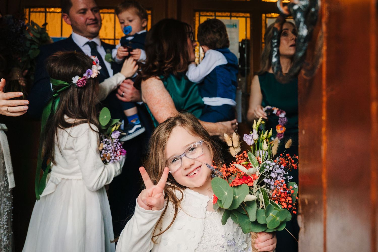 Wedding celebration with guests dancing and enjoying festivities in warm lighting.